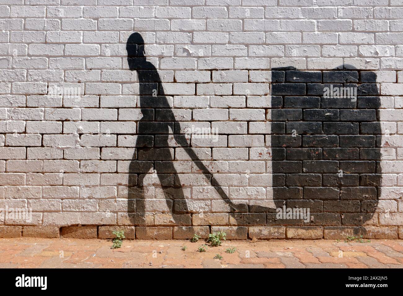 Street Art im Silhouette- oder Schattenformat, das die Entschlossenheit zeigt, hart für ein Einkommen aus dem Lebensunterhalt zu arbeiten und trotz der Chancen weiter zu gehen Stockfoto