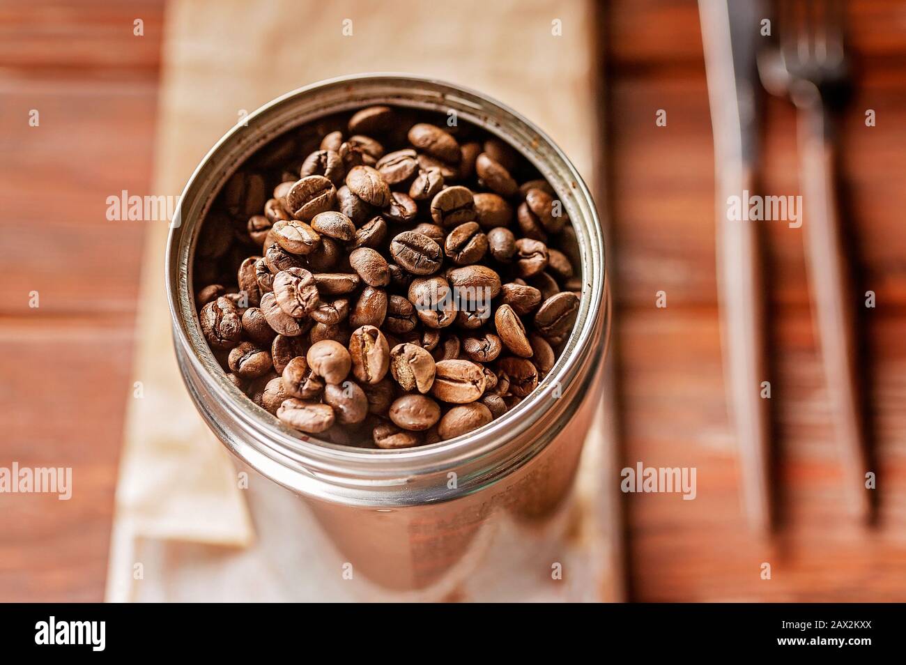 Kaffeebohnen in einer Dose. Gerösteter aromatischer Kaffee aus nächster Nähe. Sonnenlicht auf dem Hintergrund Stockfoto