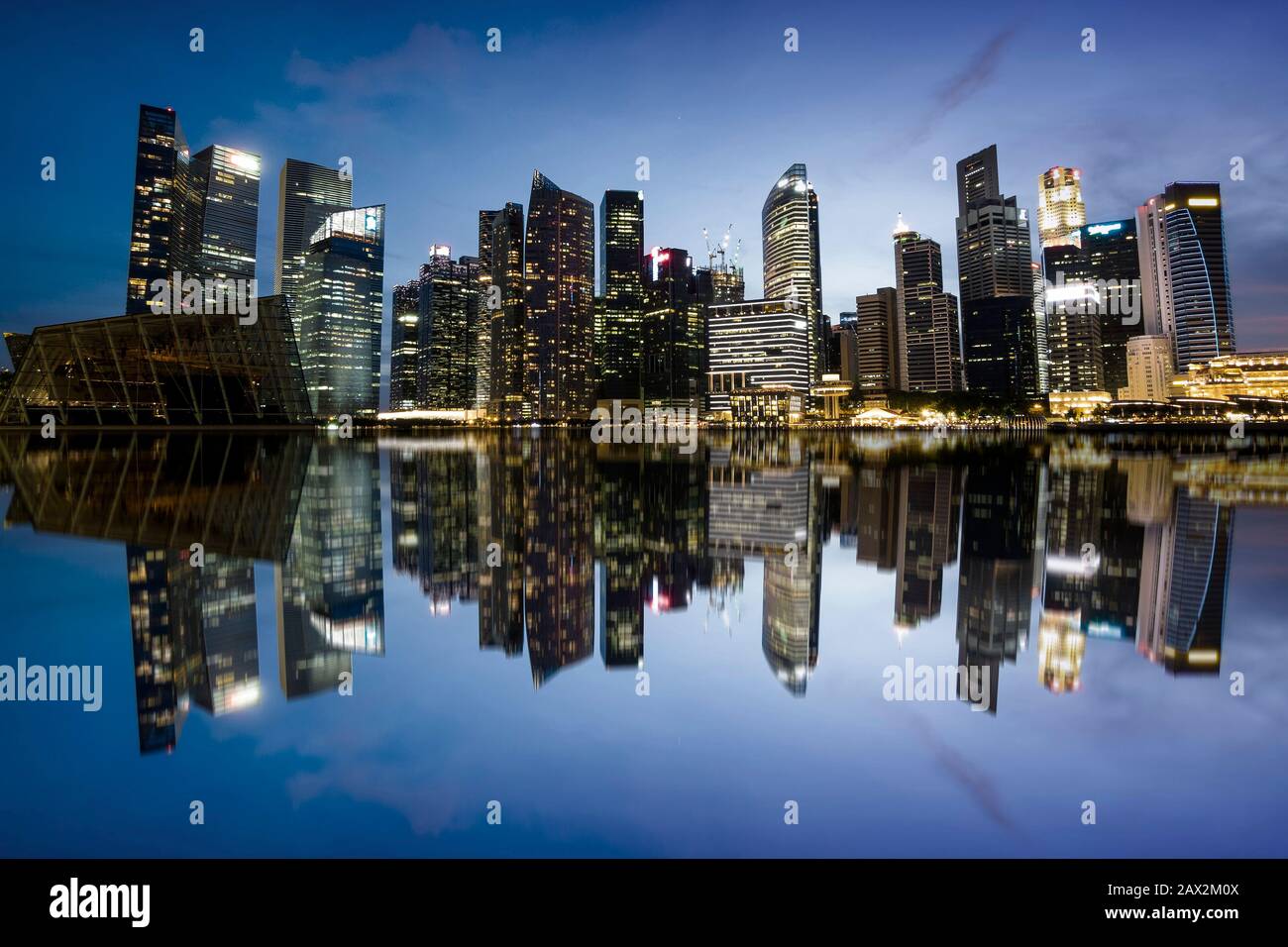 Die Skyline der Stadt Singapur am Abend zeigt Bürogebäude im Finanzviertel, die sich auf dem Wasser niederschlugen. Stockfoto