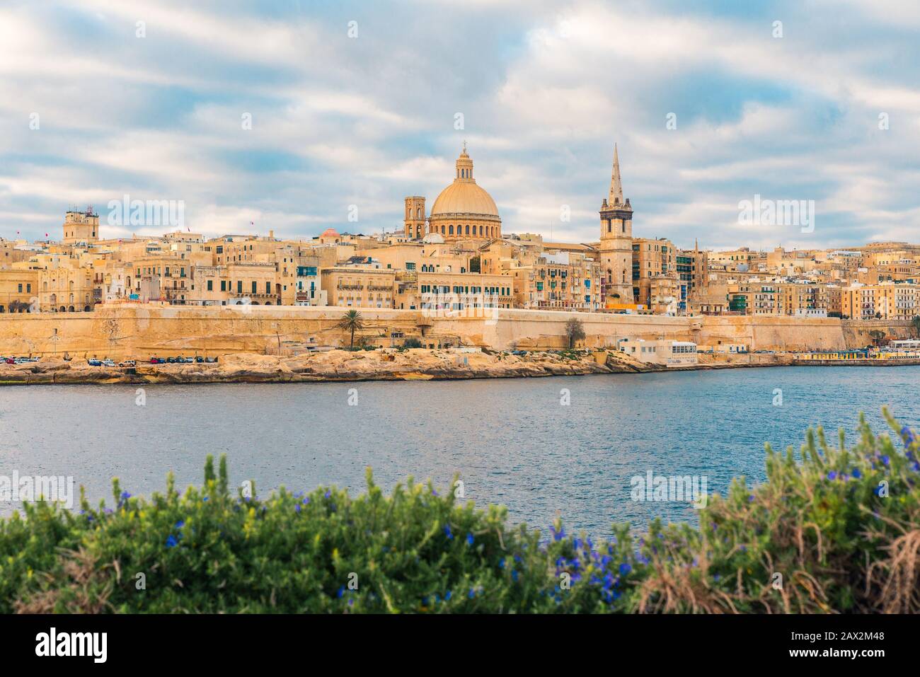 Valletta, die Skyline der Altstadt Maltas von Sliema auf der anderen Seite des Hafengeländes bei Sonnenaufgang Stockfoto