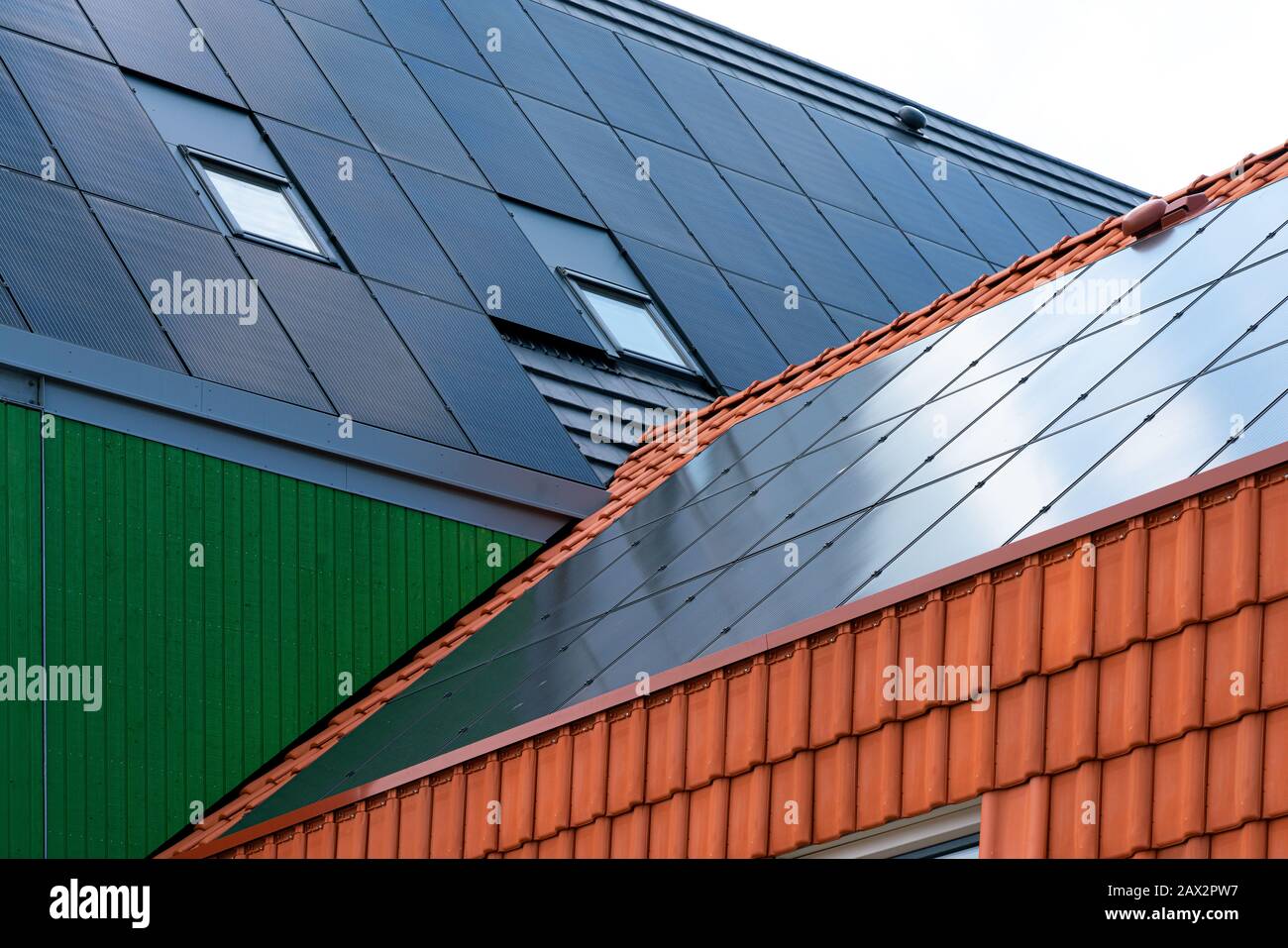 Sonnenkollektoren auf einem mit Holz und Dachschindel verkleideten Haus Stockfoto