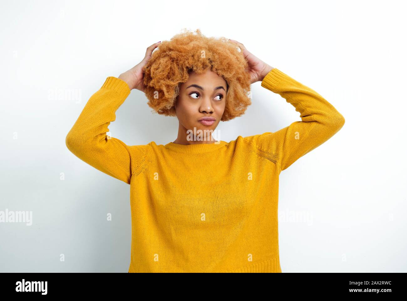 Afrikanische junge Frau hält an lockigen Haaren fest. Stockfoto