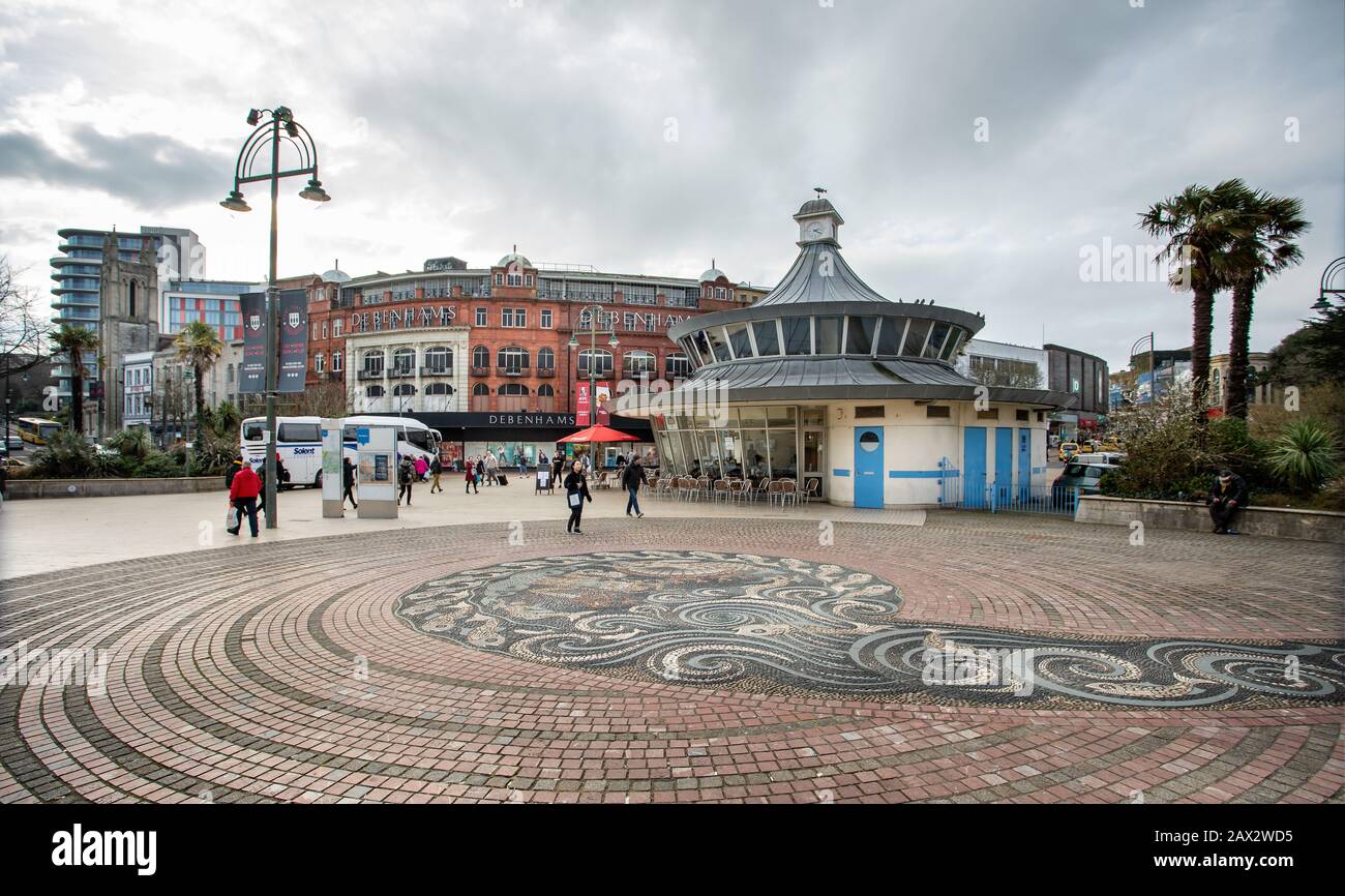 Der Platz mit Kieselmosaik im Straßenbelag mit Debenhams Laden und Personen, die draußen im Obscura Street Café im Stadtzentrum von Bournemouth, Bournemou, sitzen Stockfoto