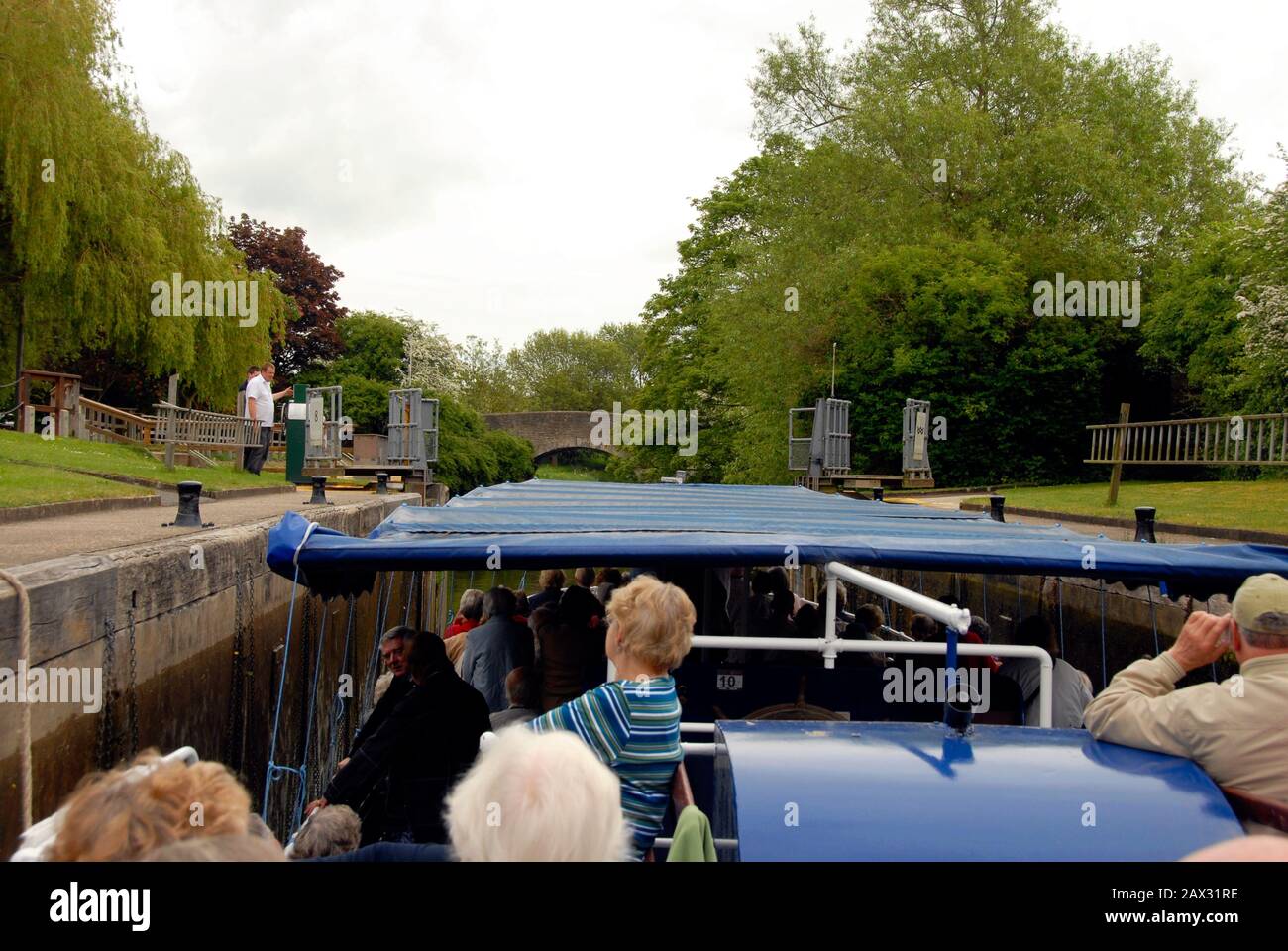 Hauptsächlich ältere Passagiere auf einem Boot in einer Schleuse an der Themse, England mit den weit geöffneten Toren, nachdem die Wasserralle gefallen ist Stockfoto
