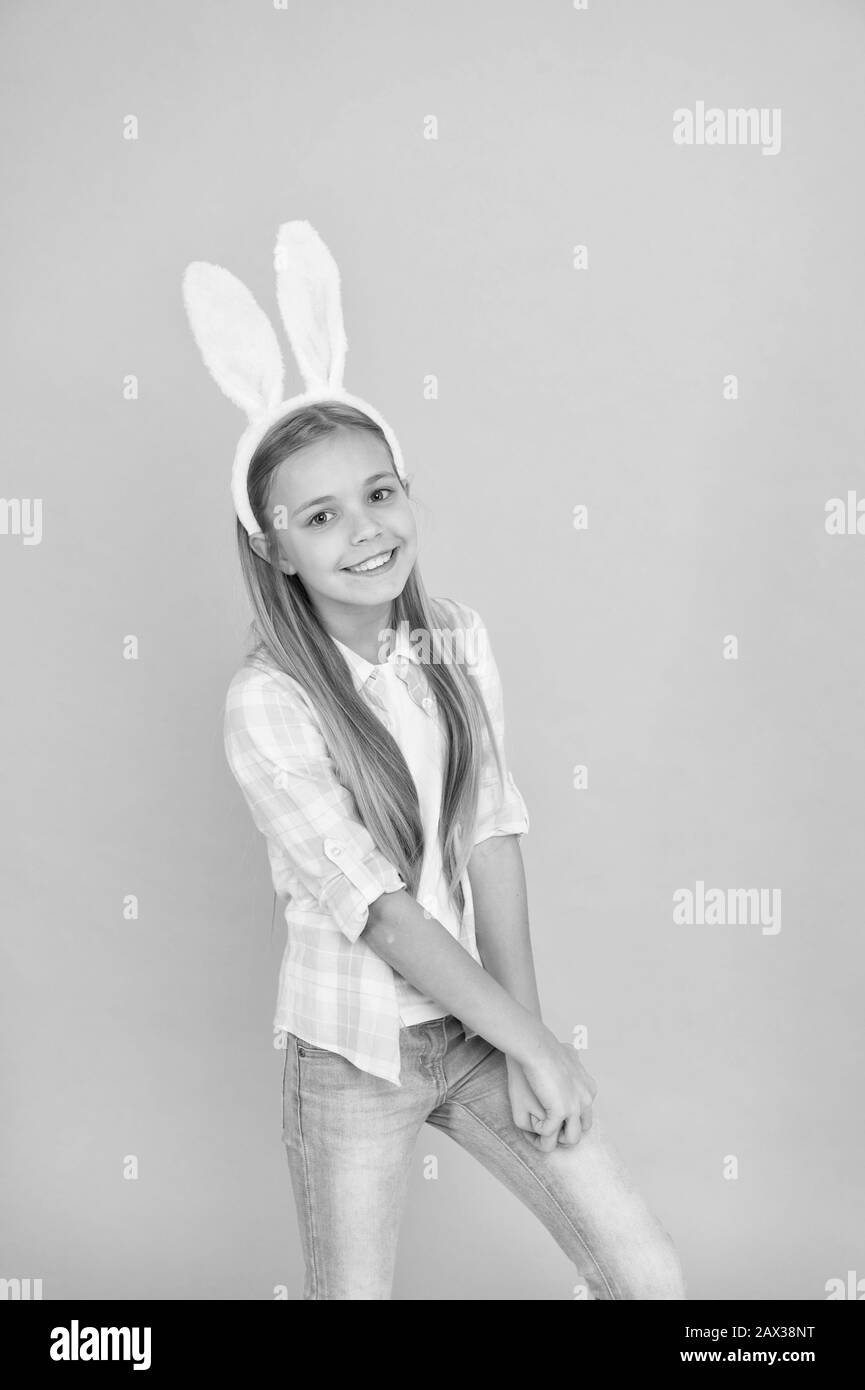 Cute Bunny. Urlaub Bunny Girl mit niedlichen lange Ohren posieren. Kind lächelnd spielen Bunny Rolle. Glückliche Kindheit. Traditionen für Kinder zu helfen in Ostern Geist zu erhalten. Bunny Ohren Zubehör. Ostern Aktivitäten. Stockfoto