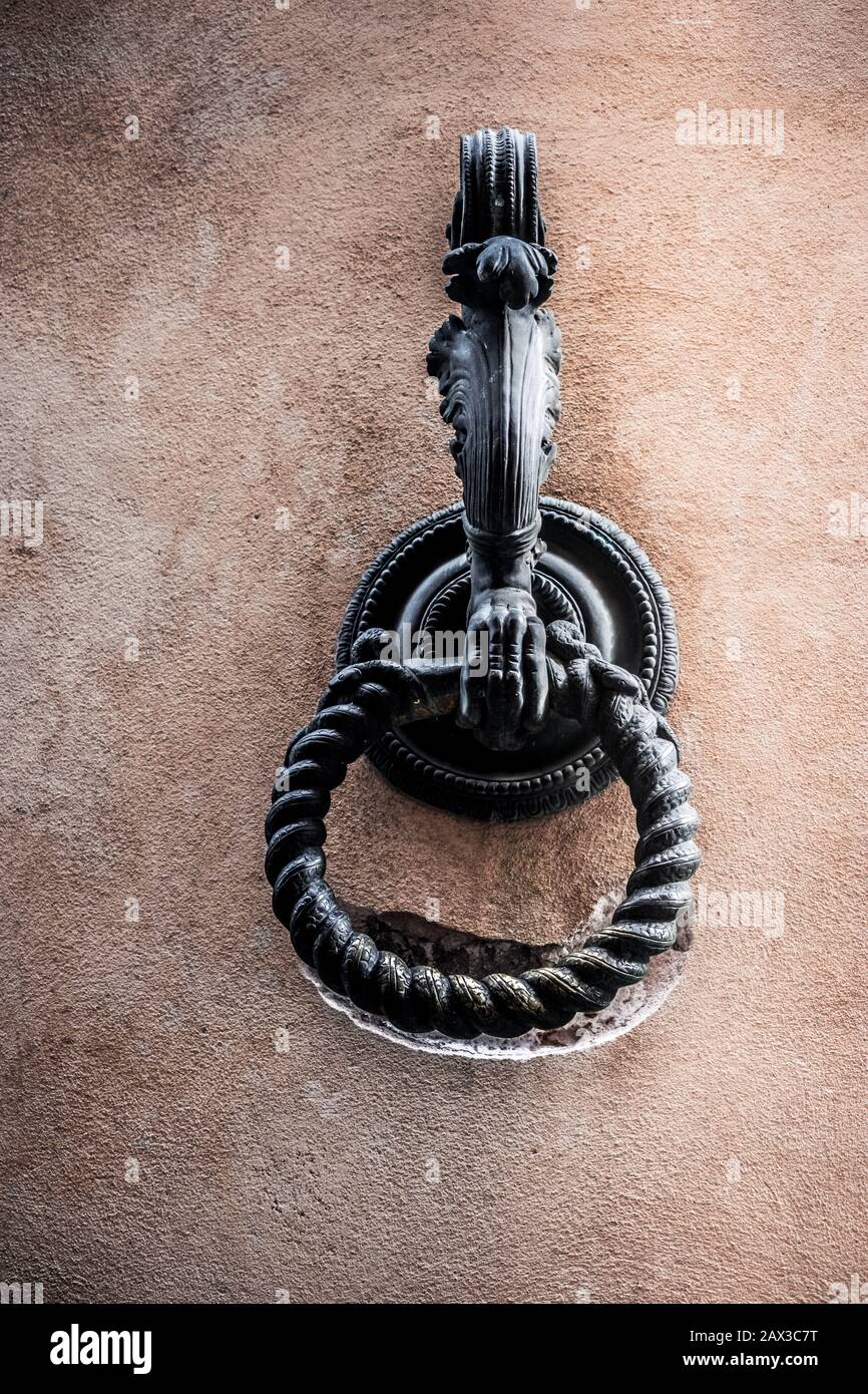 Der alte verzierte Metallring, der ursprünglich zum Binden von Pferden mit dem Ring verwendet wurde, trug eine Nut in die alte Mauer Siena, Toskana, Italien Stockfoto