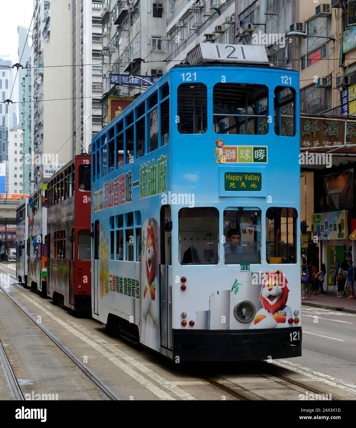 Vier Straßenbahnen in einer Linie warten darauf, dass sich die Ampel auf einer Straße auf der Insel Hongkong, China, ändert Stockfoto