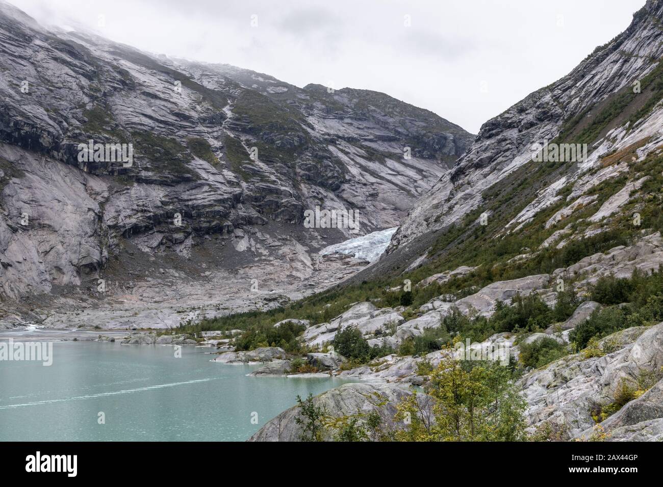 Norwegen Berge Landschaft Blick in der Nähe des Sees mit azurblauem Wasser, Felsen, Gletscher, Schnee. Bewölkte Tages-Tracking-Reise nach Nigardsbreen in Jostedalsbreen Nati Stockfoto