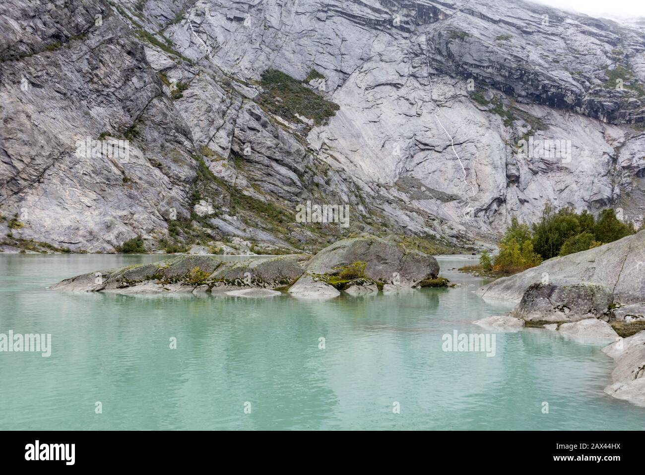 Norwegen Berge Landschaft Blick in der Nähe des Sees mit azurblauem Wasser, Felsen, Gletscher, Schnee. Bewölkte Tages-Tracking-Reise nach Nigardsbreen in Jostedalsbreen Nati Stockfoto