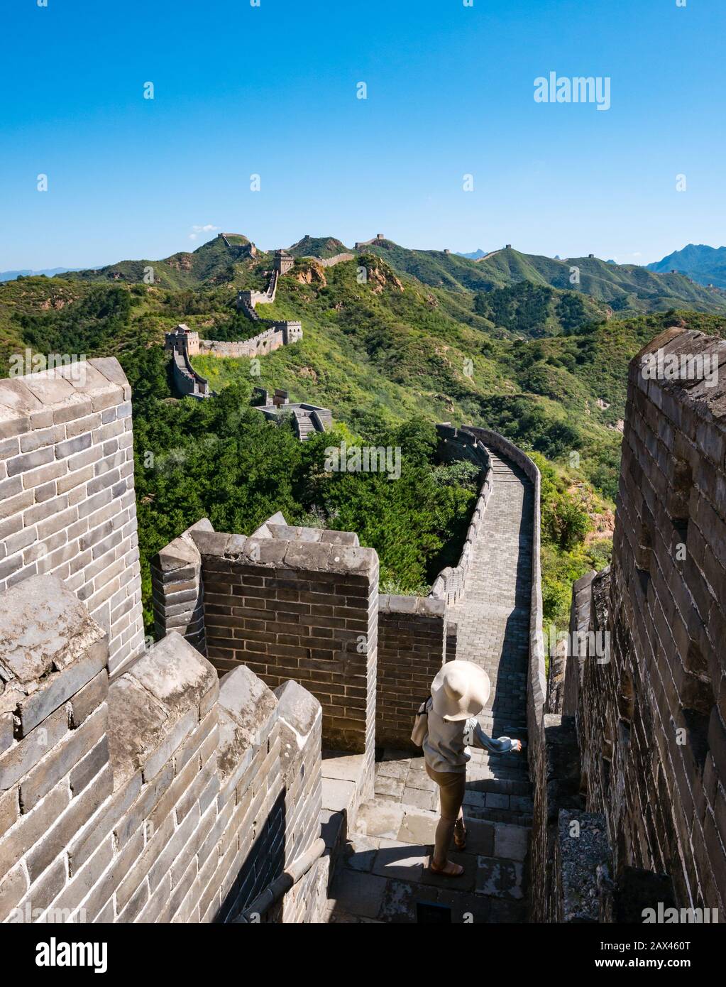 Frau mit breitem Krempelhut Ming-Dynastie Jinshanling Große Mauer von China mit Wachtürmen, die in die Ferne auf dem Bergrücken, China, Asien führen Stockfoto