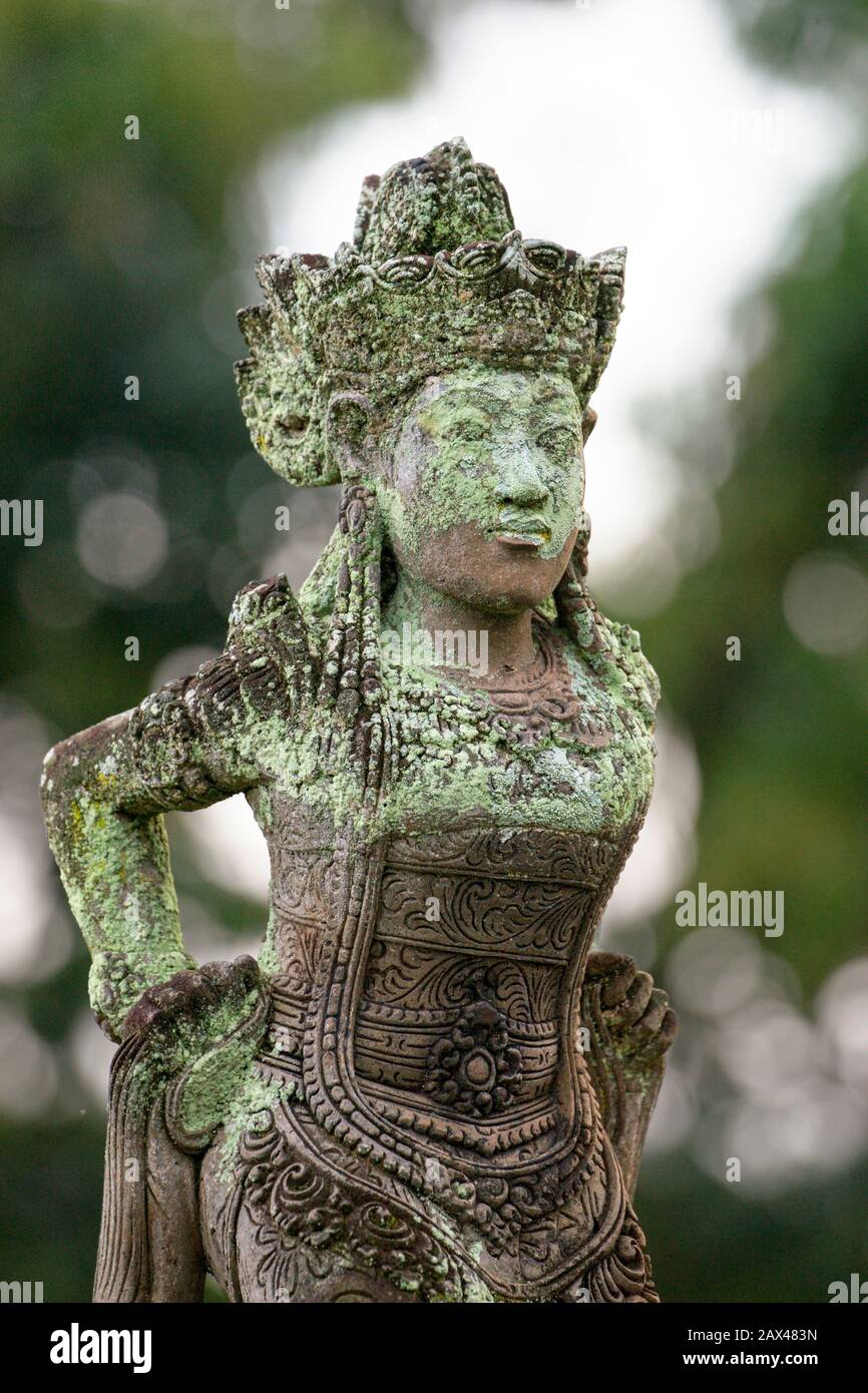 Eine Steinstatue eines weiblichen Hindu-Gottes oder einer Frömmigkeit. Bali, Indonesien. Ausschnitt. Weißer Hintergrund. Stockfoto