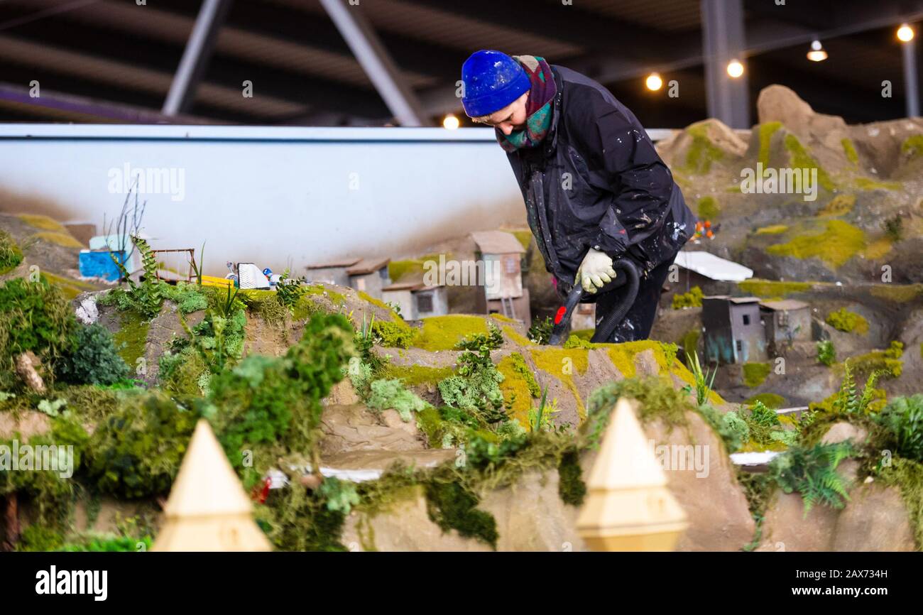 Bispingen, Deutschland. Februar 2020. Ein Modellbauer verwendet einen  Staubsauger, um Teile des Modelleisenbahnsystems zu reinigen, das unter der  Skihalle Snow Dome gebaut wird. Unter der Skihalle Snow Dome wird nach  Angaben der