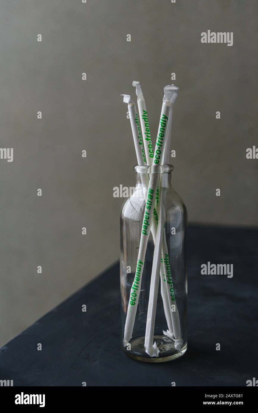 Nicht verwendete Papierstraten in Glasflasche auf Betontisch Stockfoto