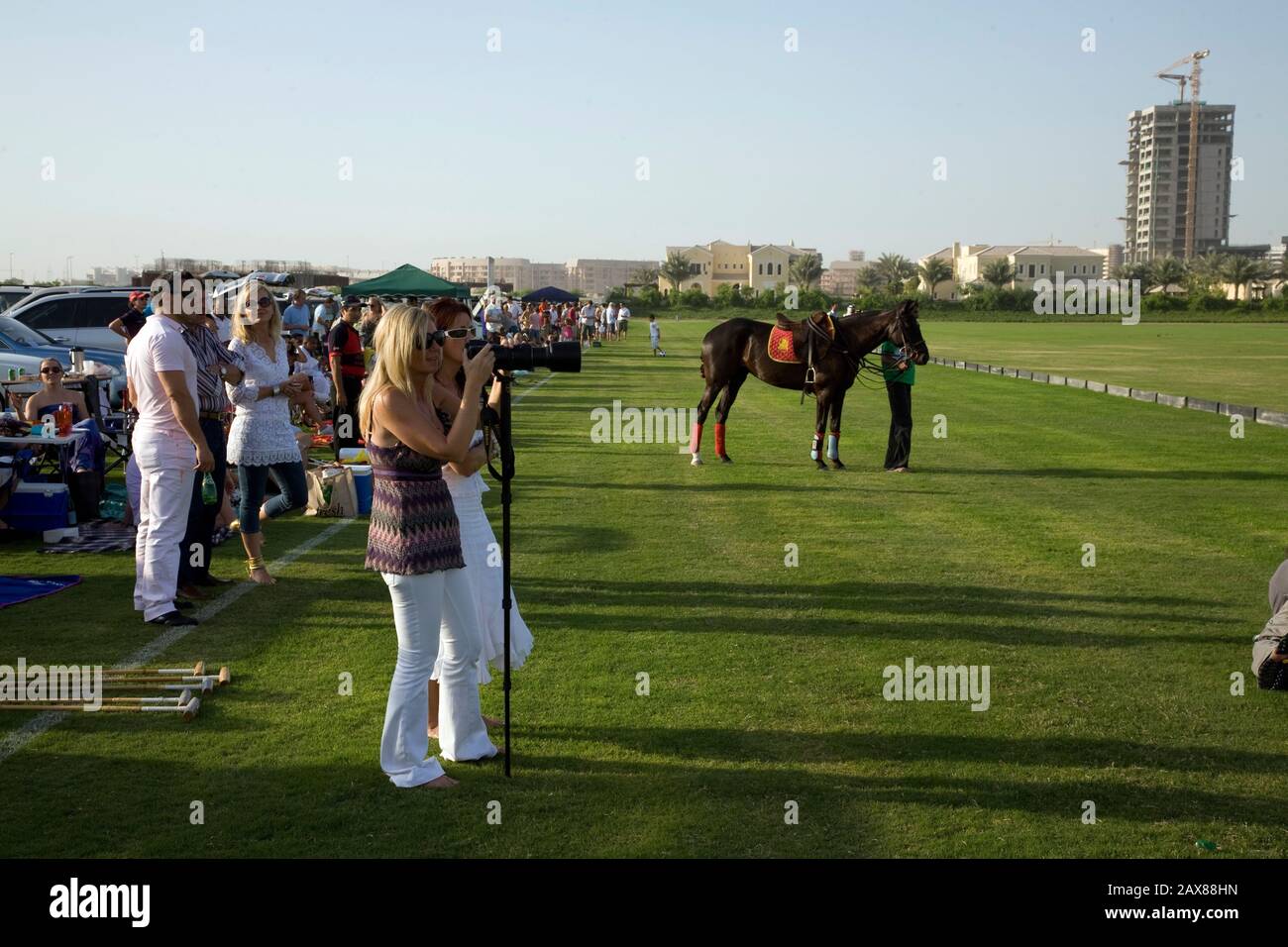 Die Zuschauer sehen das Geschehen eines späten Nachmittag Polospiels auf dem Poloclub Gelände in Dubai, VAE. Stockfoto