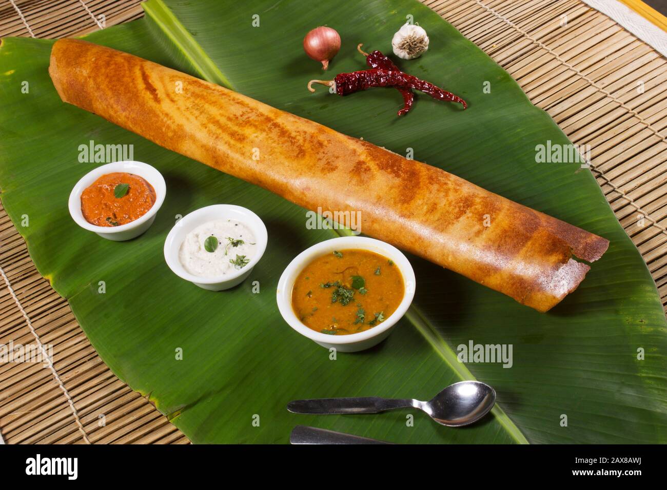 Masala dosa auf Bananenblatt mit Sambar und Kokosnusschutney. Südindischer Vegetarier-Snack Stockfoto