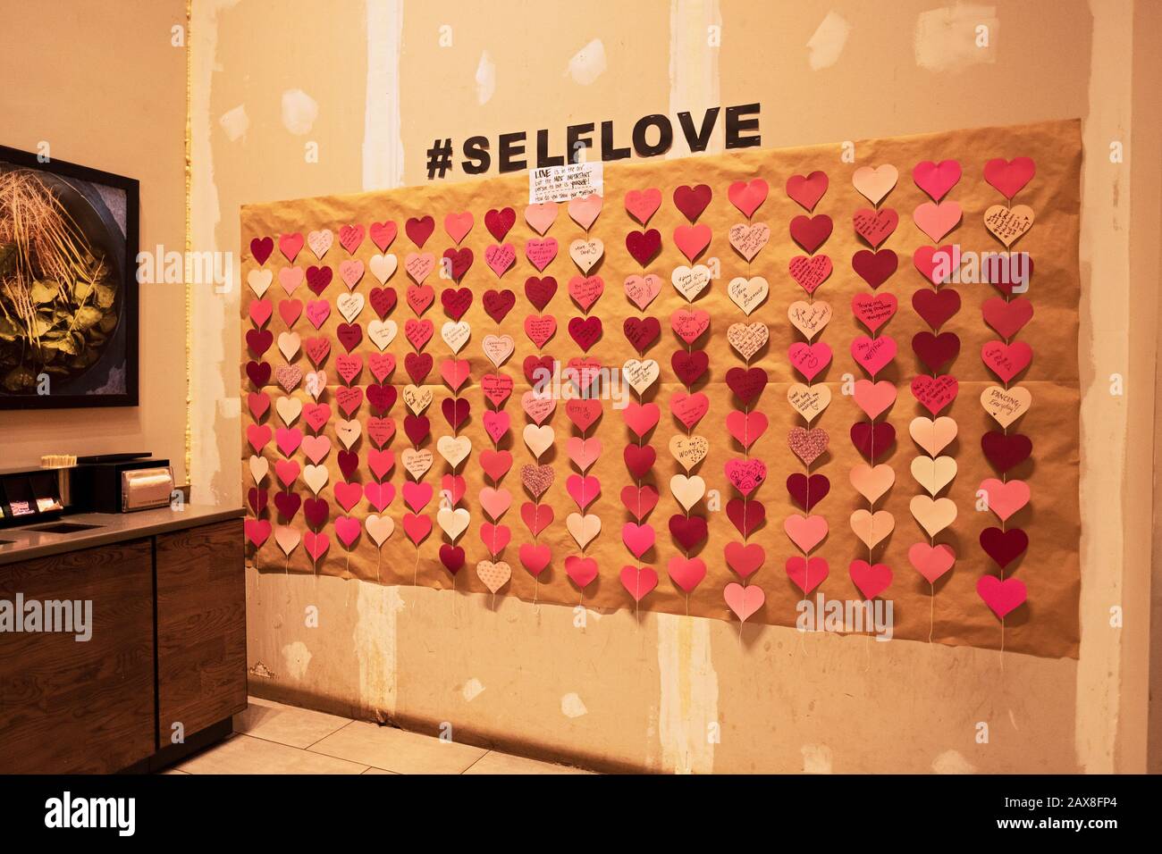#SELFLOVE. Eine interaktive Wand in einer Midtown Manhattan Starbucks bittet die Gäste, Selbstliebe Botschaften zu Ehren des Valentinstages zu schreiben. Stockfoto