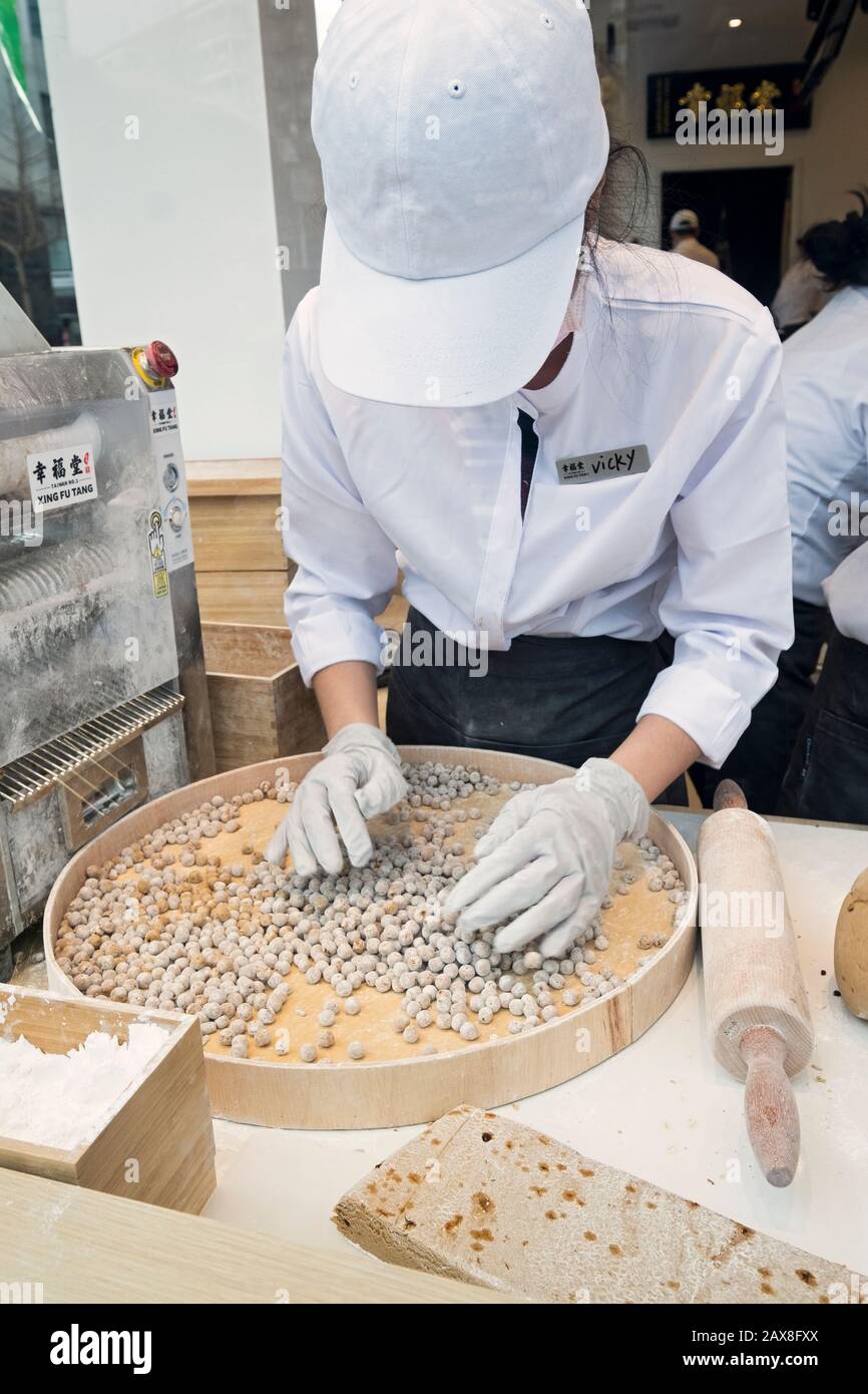 Ein junger Asian American stellt Tapioka-Bälle für Boba-Getränke im Fenster von Xing Fu Tang her, einem taiwanesischen Laden in Main St. in Flushing, Queens, Chinatown Stockfoto