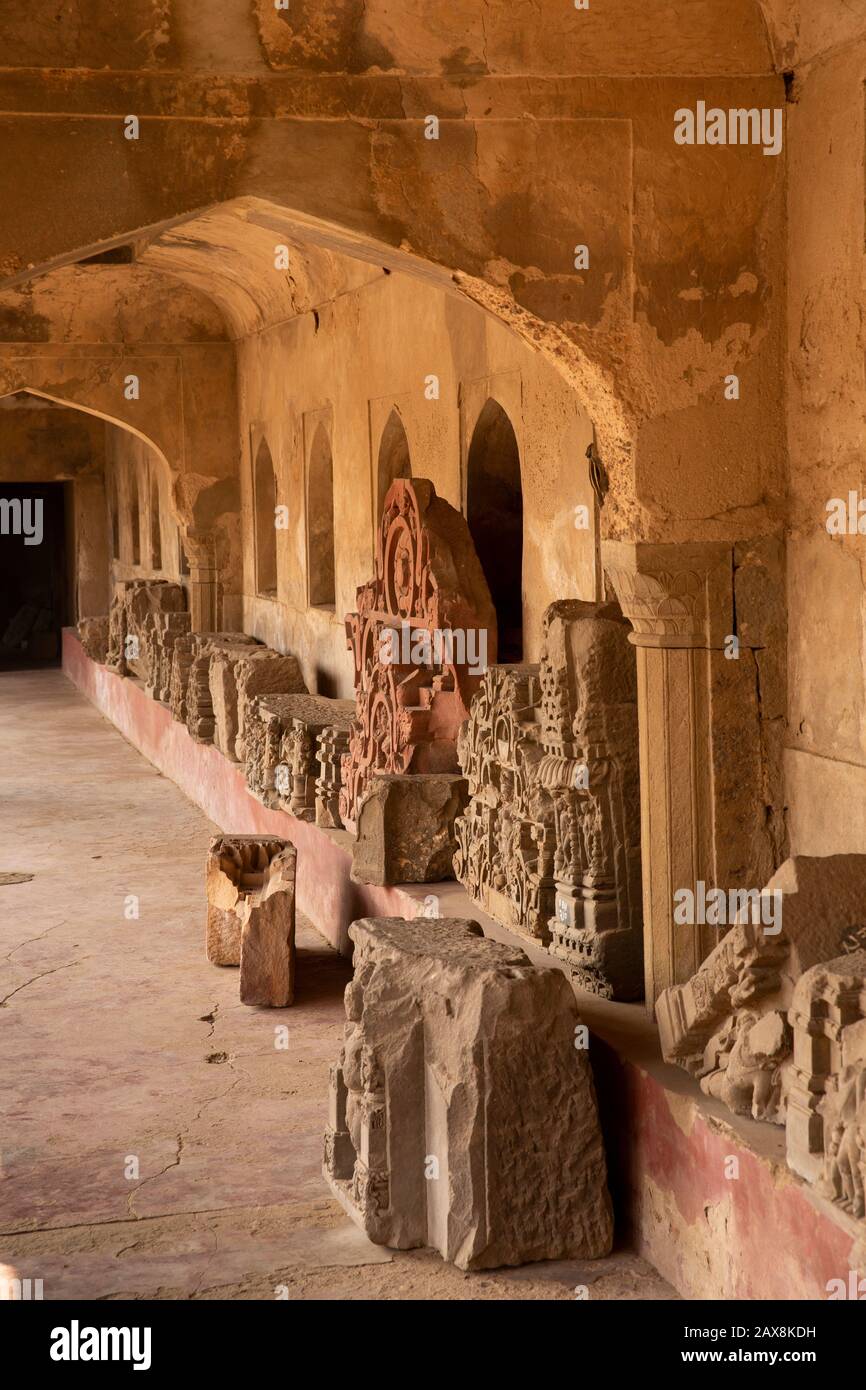 Indien, Rajasthan, Dausa, Abhaneri, Chand Baori Stepwell, Mughal Säulenarkade, uralte behauene Steine ausgestellt Stockfoto