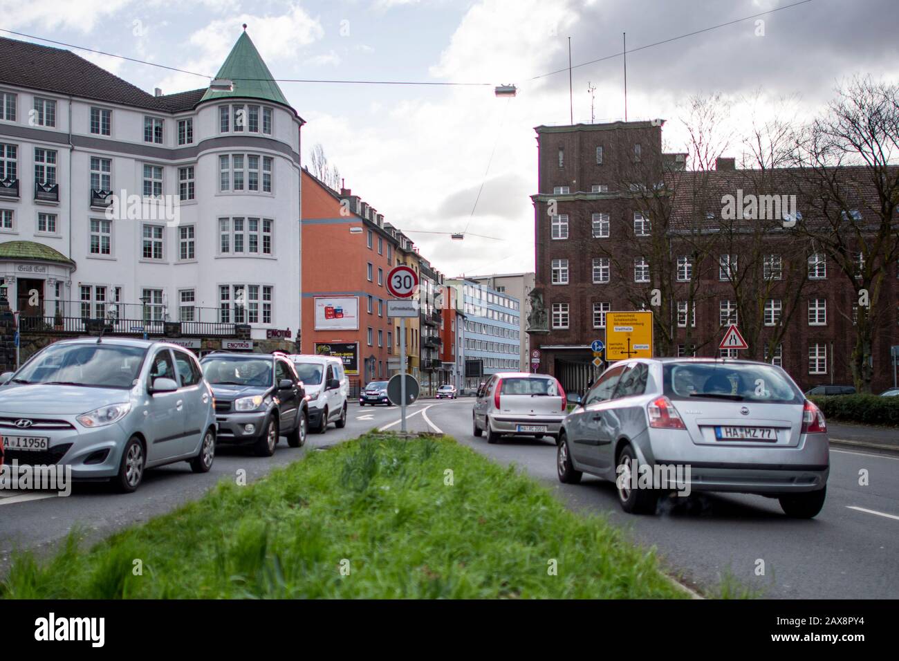 Hagen, Deutschland. Februar 2020. Fahrzeuge warten vor einer Ampel am Märkischen Ring (Bundesstraße 54) in Hagen. Im dahinter liegenden Canyon von Häusern werden die Stickstoffdioxid-Werte gemessen. Um drohende Fahrverbote für ältere Dieselfahrzeuge in Wuppertal und Hagen zu verhindern, treffen sich das Land Nordrhein-Westfalen und die Deutsche Umwelthilfe (DUH) am Dienstag zu Vermittlungsgesprächen. Das Oberverwaltungsgericht (OVG) in Münster vermittelt zwischen den Streitparteien. Credit: David Inderlied / dpa / Alamy Live News Stockfoto