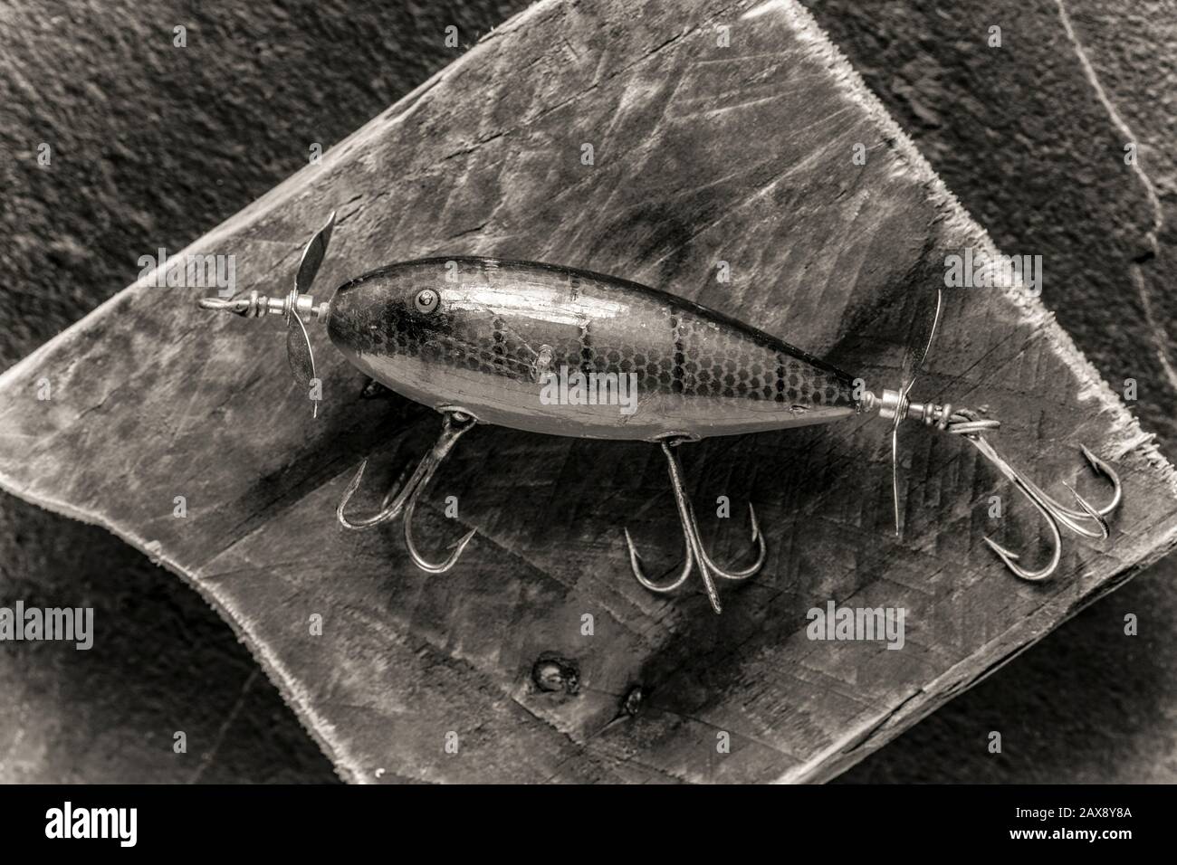 Ein alter Fischfang aus South Bend, oder Plug, der Raubfisch fangen soll, fotografiert auf einem Stück Treibholz. Die Lure stammte aus einer Sammlung von VI Stockfoto