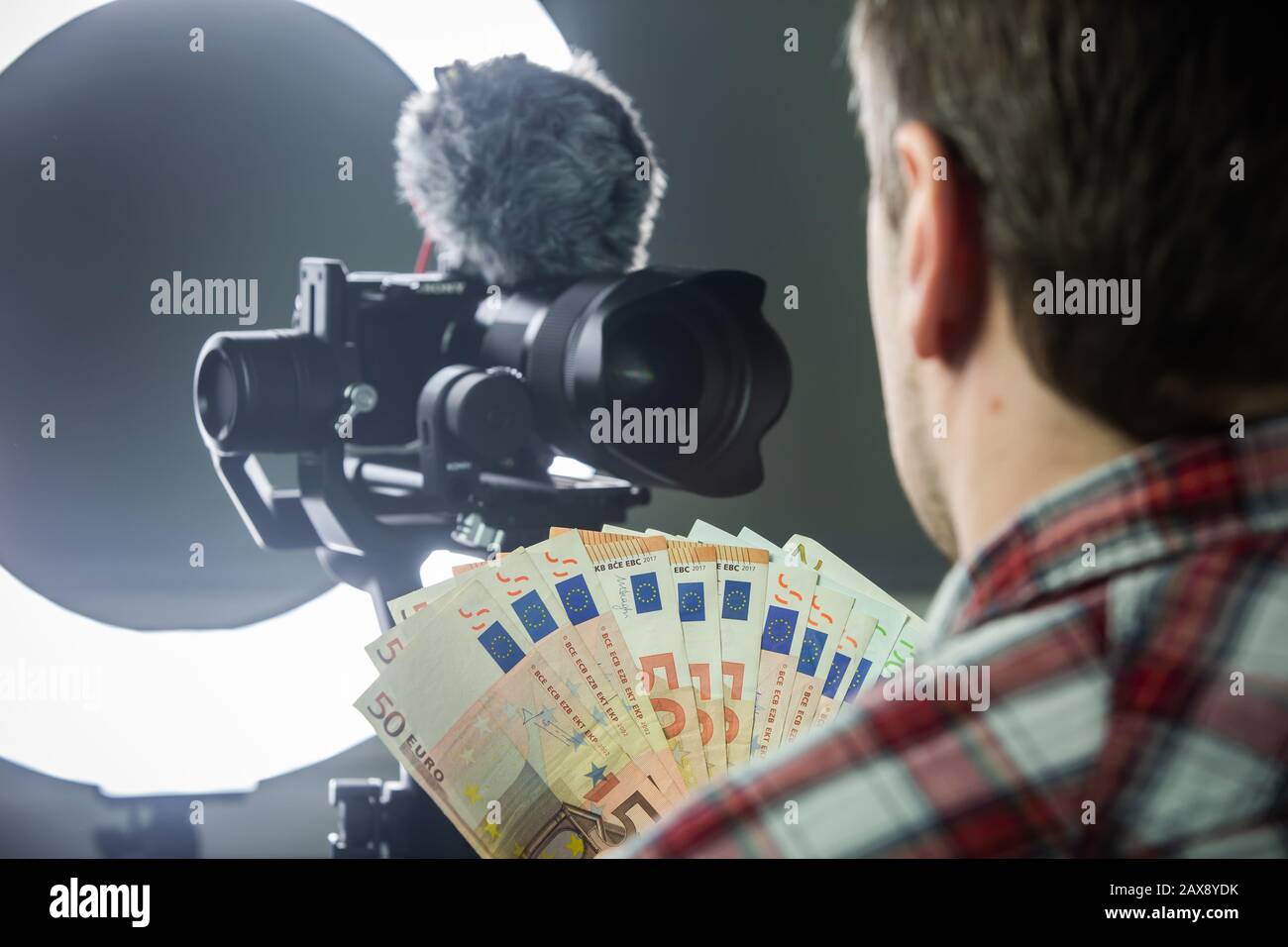 Männlicher Vlogger zählt Geld aus vlogging Stockfoto