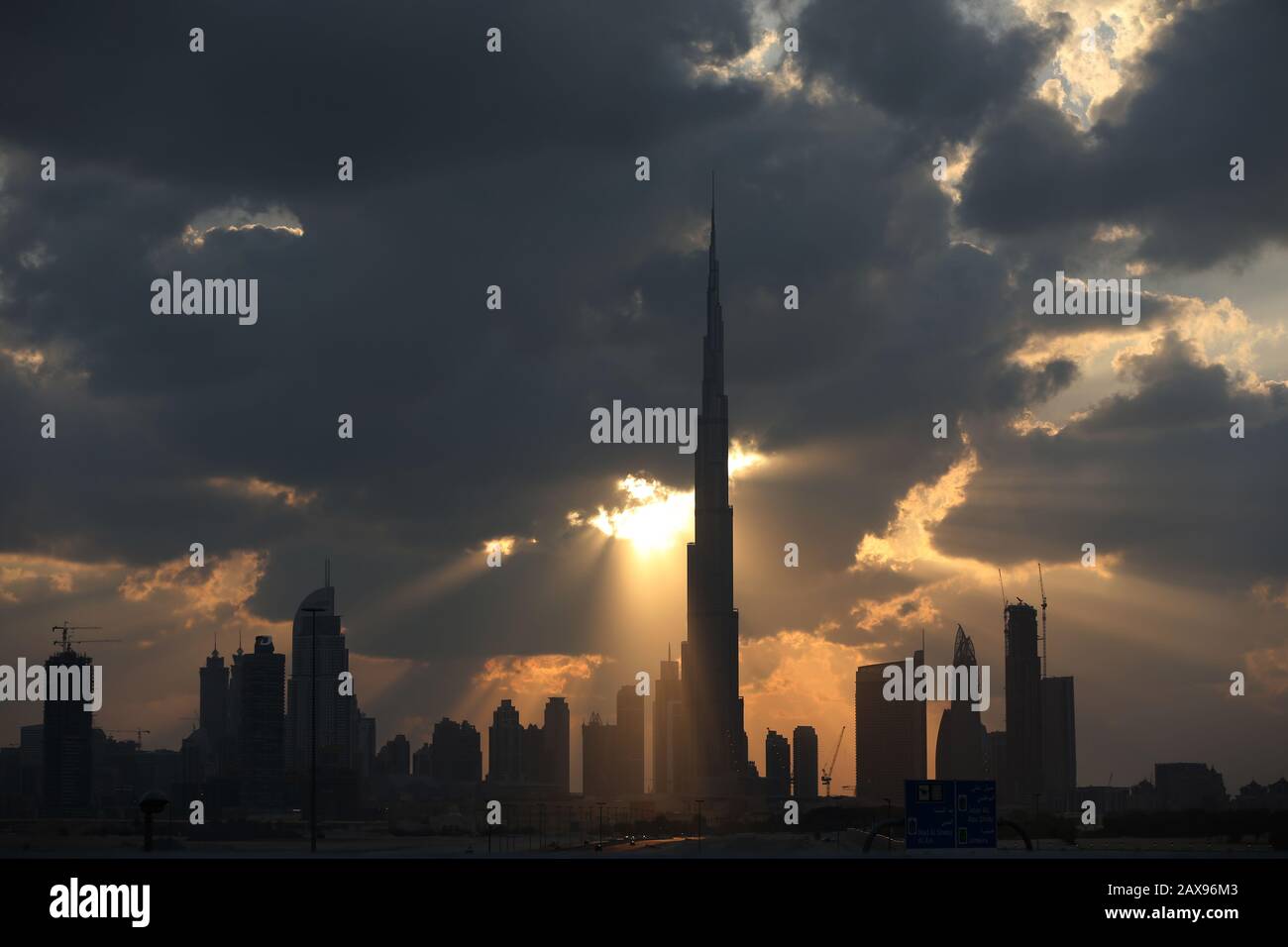 Sonnenuntergang hinter den Wolken der Skyline von Dubai und Burj Khalifa in Dubai, Vereinigte Arabische Emirate 2015. Stockfoto