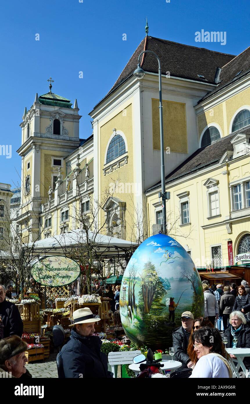 Wien, Österreich - 27. März 2016: Nicht identifizierte Personen und Arful dekoriert Riesen Osterei auf traditionellen Ostermarkt auf der Freyung Platz mit Kirche Stockfoto