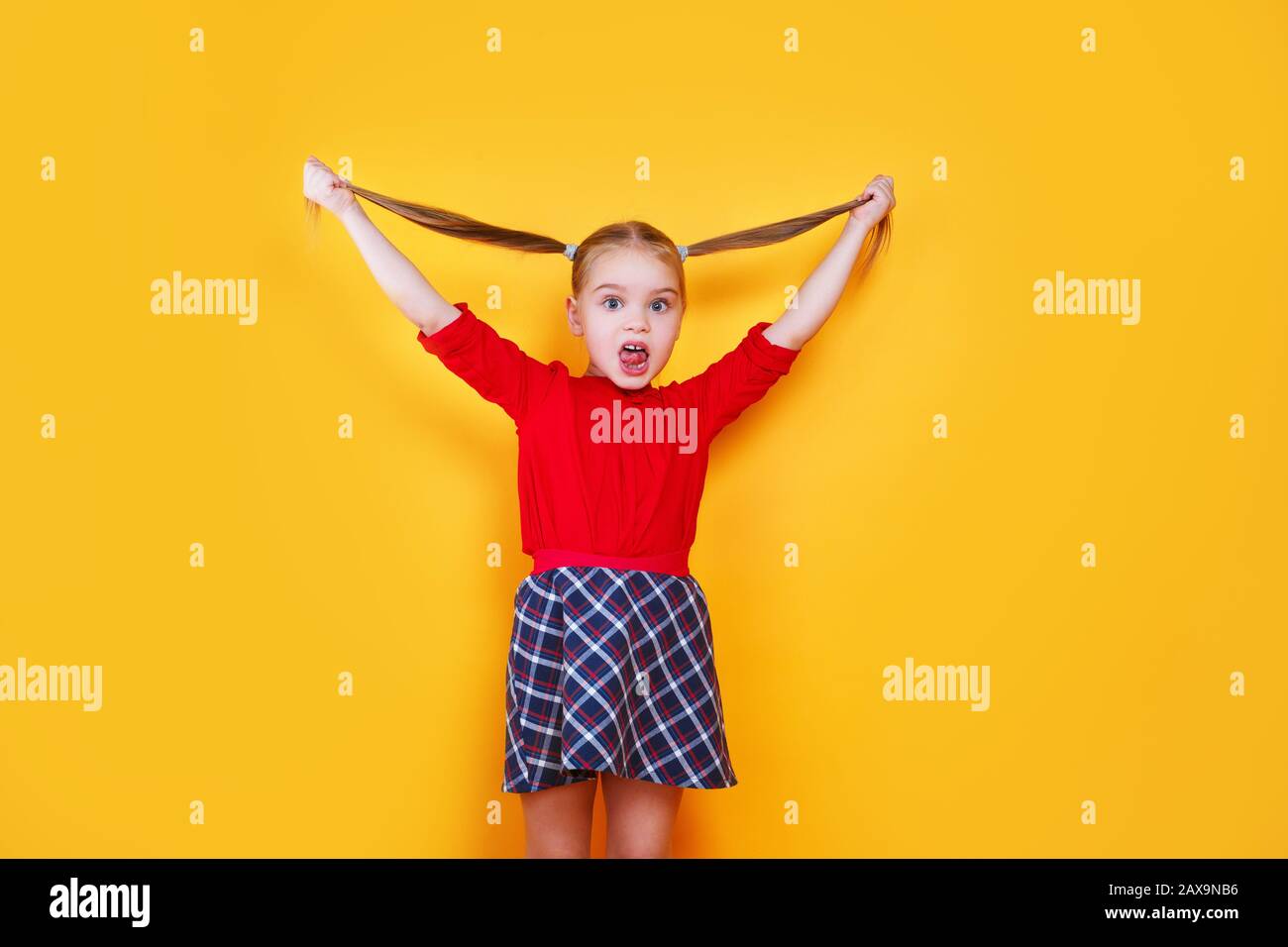 Kleines Mädchen, das sich mit lustiger Ausdrucksweise zufrieden auf die Zunge klebt. Emotionskonzept. Stockfoto