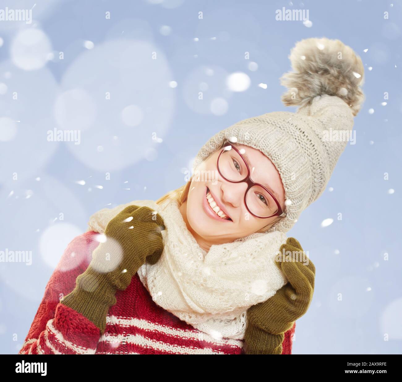 Junge lächelnde Frau im Winter im Schnee mit Winterkleidung Stockfoto