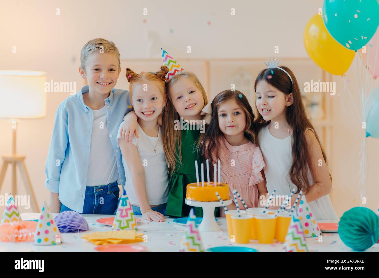 Horizontale Aufnahmen von Gruppen kleiner Kinder treffen sich, um Geburtstag zu feiern, sich mit der Kamera zu umarmen und zu posieren, sich auf besondere Anlässe vorzubereiten, steht nea Stockfoto