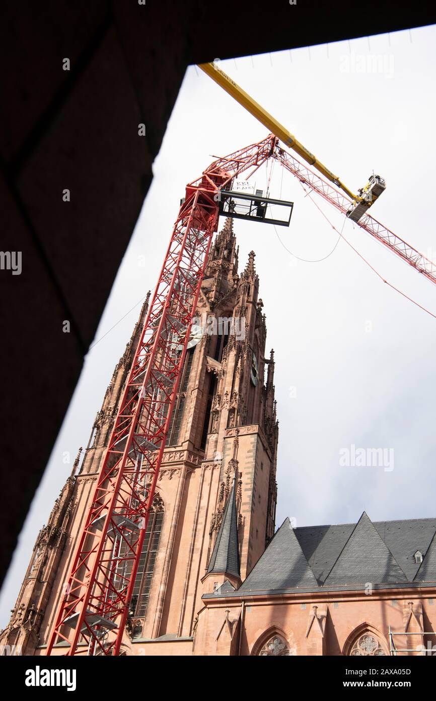 11. Februar 2020, Hessen, Frankfurt am Main: Monteure arbeiten von einer Hubplattform aus, um einen Kran zu retten, der im "Sabine"-Sturm beschädigt wurde. Sein Jib war auf das Dach der Kathedrale gefallen. Foto: Boris Roessler / dpa Stockfoto