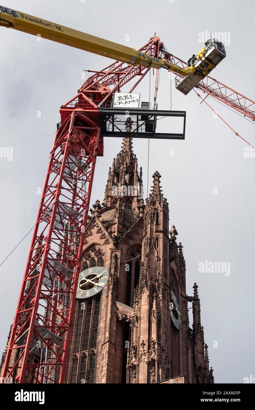 11. Februar 2020, Hessen, Frankfurt am Main: Monteure arbeiten von einer Hubplattform aus, um einen Kran zu retten, der im "Sabine"-Sturm beschädigt wurde. Sein Jib war auf das Dach der Kathedrale gefallen. Foto: Boris Roessler / dpa Stockfoto