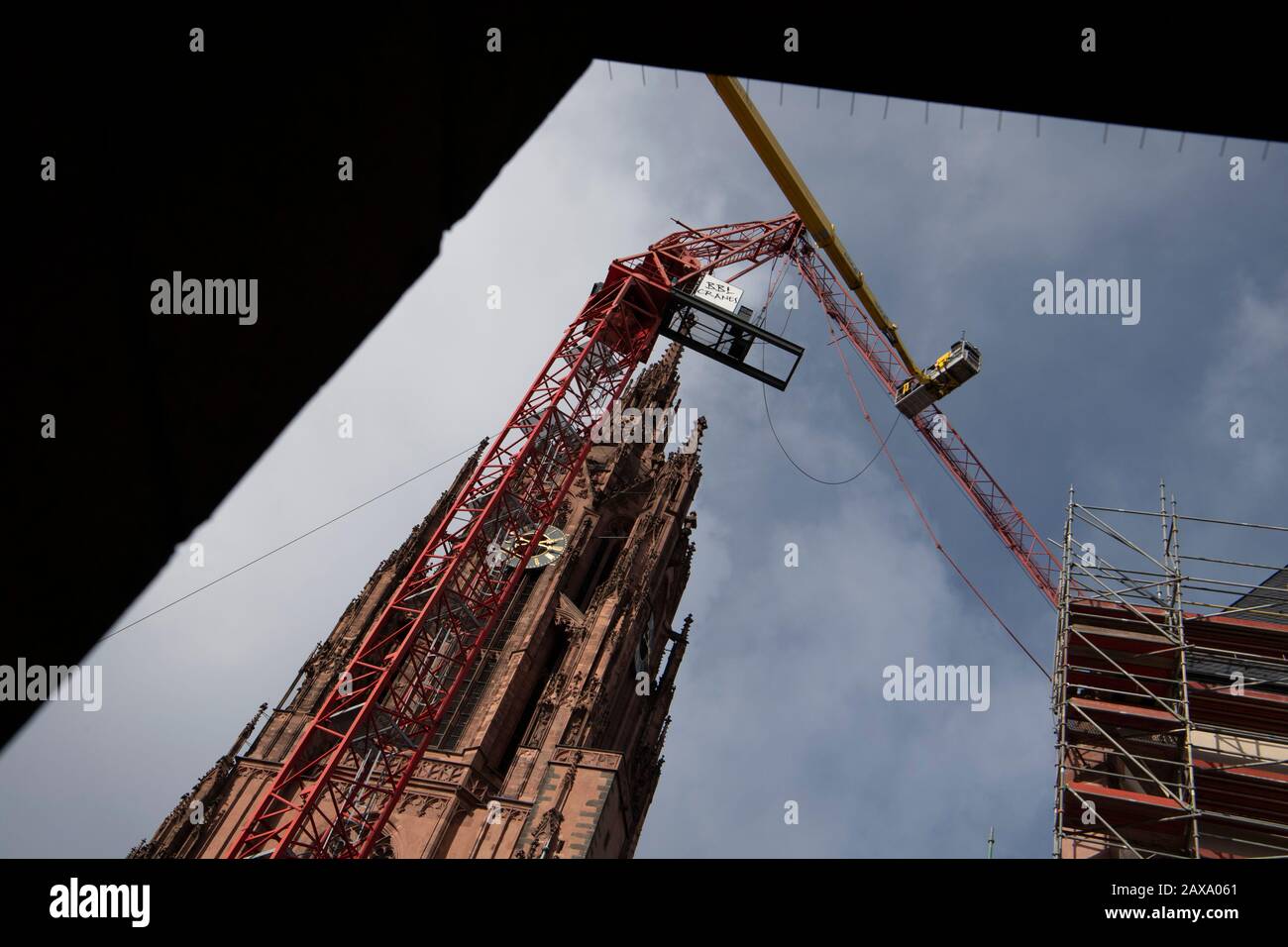 11. Februar 2020, Hessen, Frankfurt am Main: Monteure arbeiten von einer Hubplattform aus, um einen Kran zu retten, der im "Sabine"-Sturm beschädigt wurde. Sein Jib war auf das Dach der Kathedrale gefallen. Foto: Boris Roessler / dpa Stockfoto