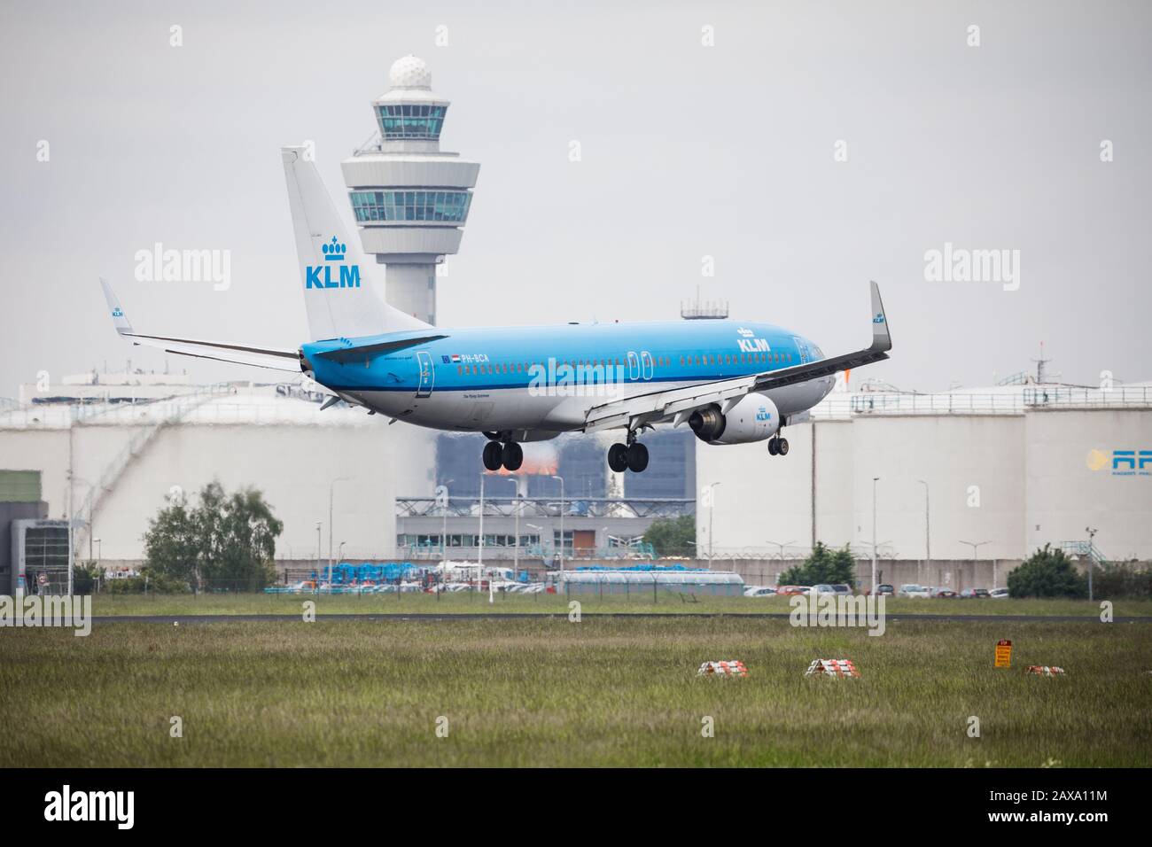 KLM Royal dutch Airline Boeing 737 landet auf dem Flughafen Schiphol Amsterdam, mit dem Kontrollturm im Hintergrund Stockfoto