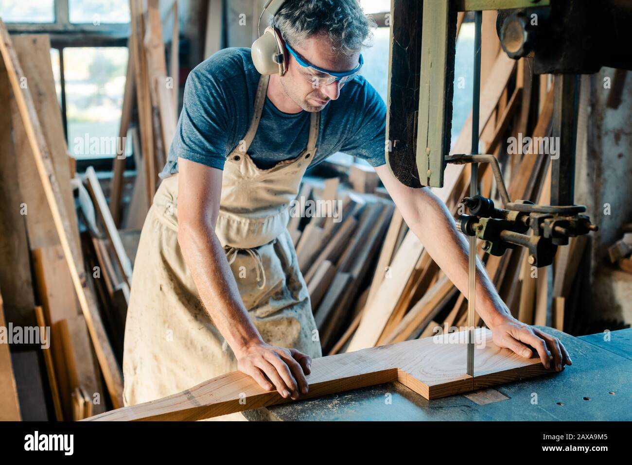 Tischler auf dem Band sah in seiner Holzwerkstatt Stockfoto