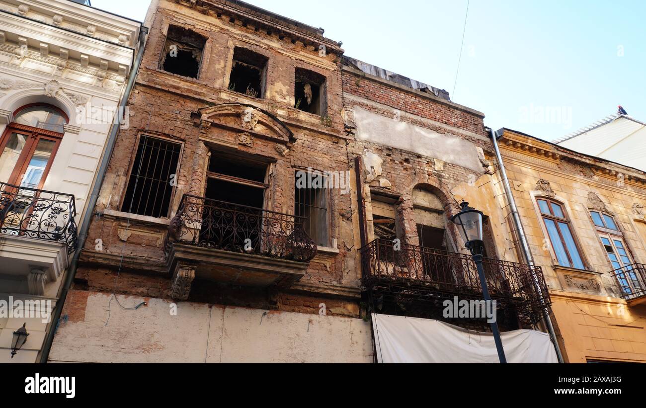 Fassade eines sehr alten Ziegelhauses oder Gebäudes verfiel und war in der Ruine. Beschädigte oder zerstörte Wohnung oder Gebäude ohne Fenster Stockfoto