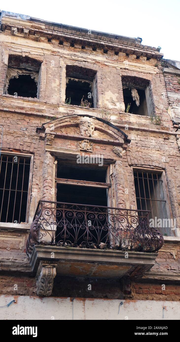 Fassade eines sehr alten Ziegelhauses oder Gebäudes verfiel und war in der Ruine. Beschädigte oder zerstörte Wohnung oder Gebäude ohne Fenster Stockfoto