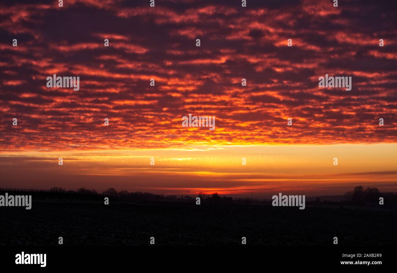 Sonnenaufgang, der auf der Unterseite der Wolken reflektiert wird und einen Brummeffekt im Lot-et-Garonne, Frankreich, verursacht. Stockfoto