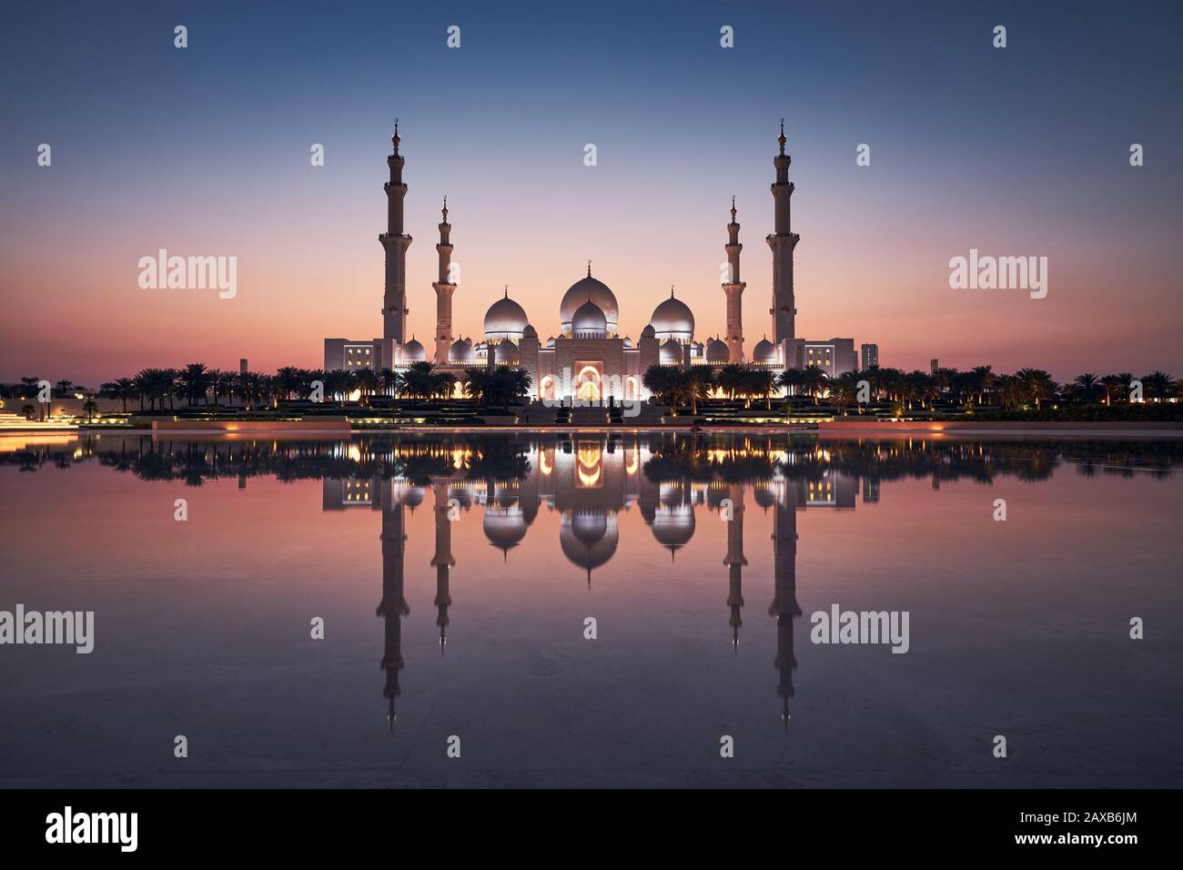 Abu Dhabi bei Sonnenuntergang. Außenansicht auf beleuchtete Moschee. Vereinigte Arabische Emirate. Stockfoto