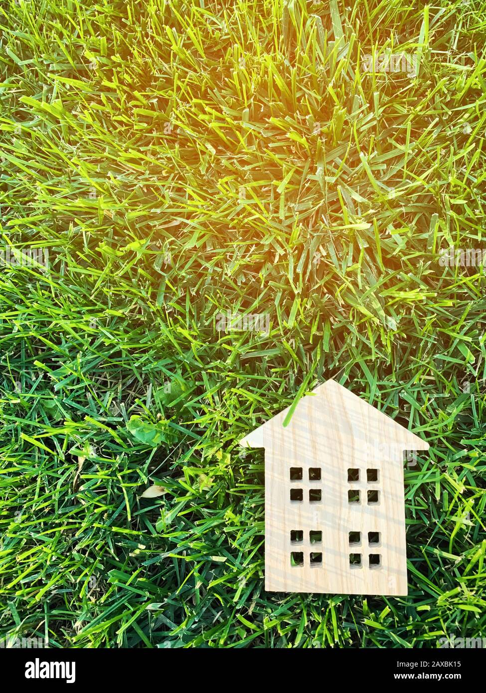 Kleines Holzhaus auf grünem Gras. Immobilienkonzept. Modernes Gehäuse. Umweltfreundliches und energieeffizientes Haus. Ein Haus außerhalb der Stadt kaufen. N Stockfoto