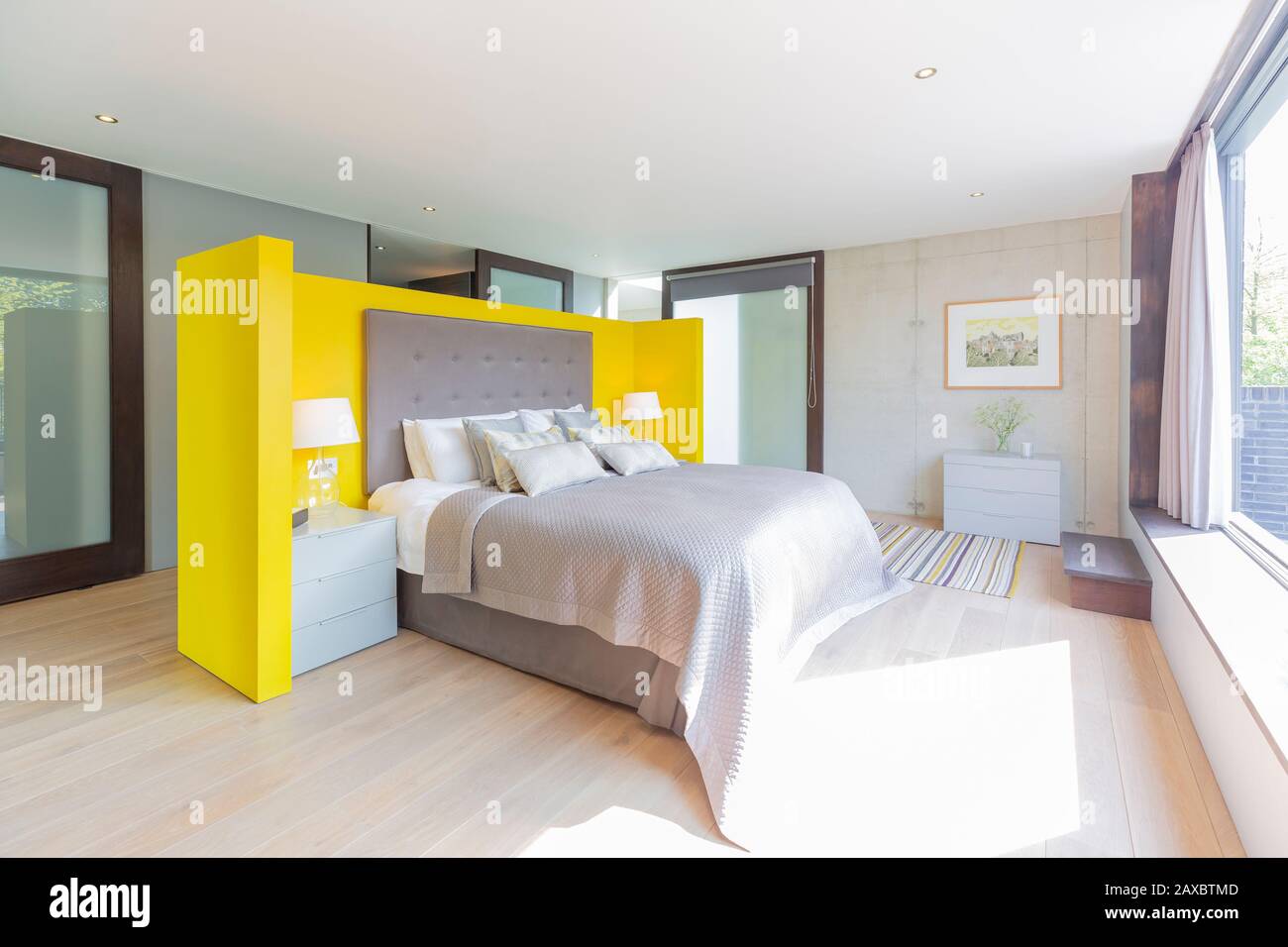 Modernes Schlafzimmer mit gelbem und grauem Kopfteil Stockfoto