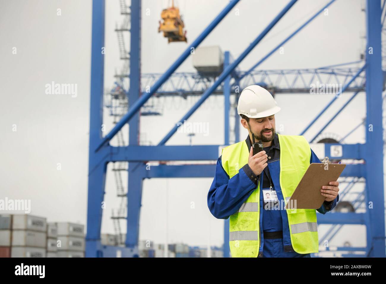 Hafenarbeiter mit Walkie-Talkie und Clipboard auf der Werft Stockfoto