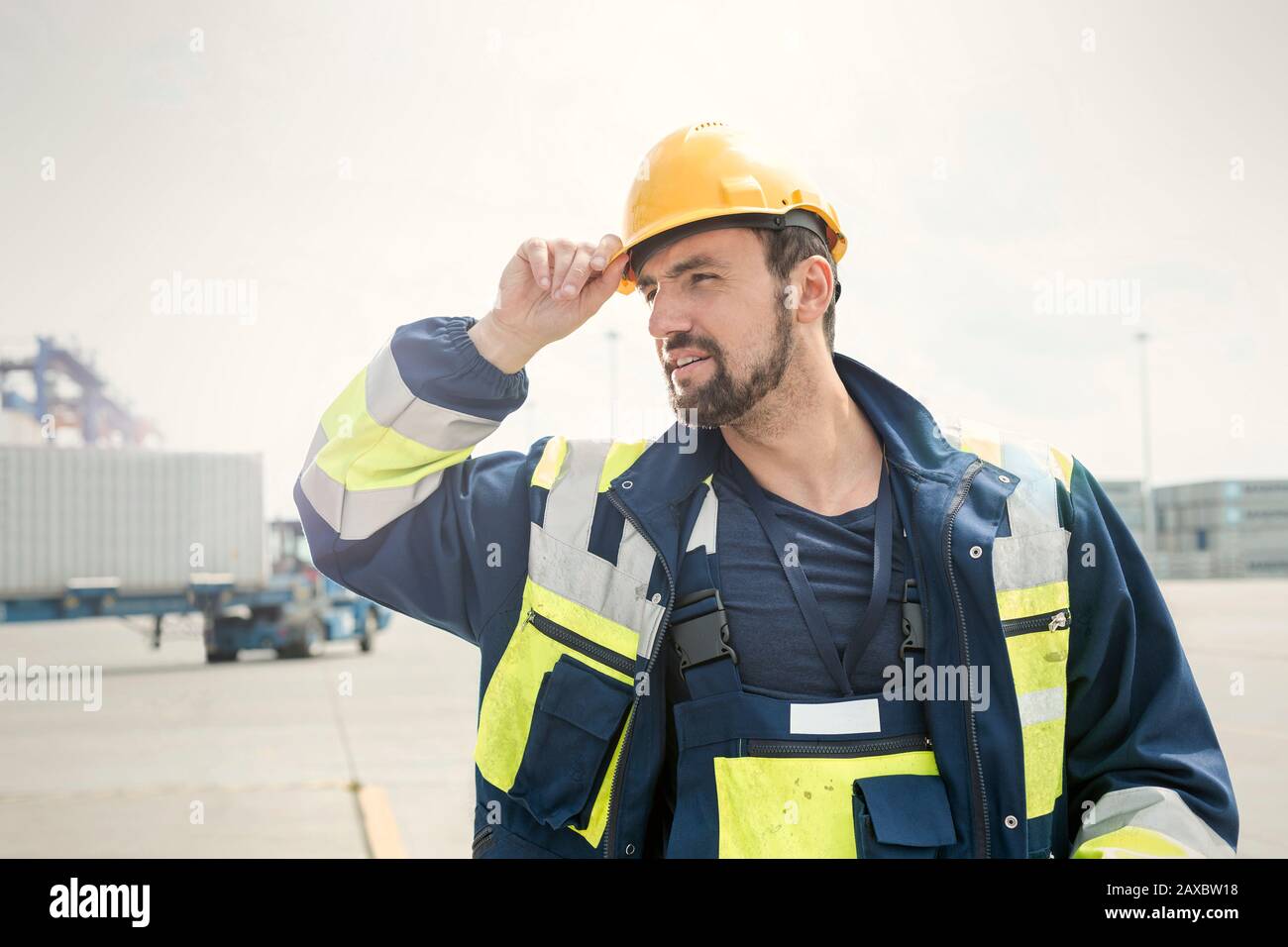 Hafenarbeiter mit Hut auf sonniger Werft Stockfoto