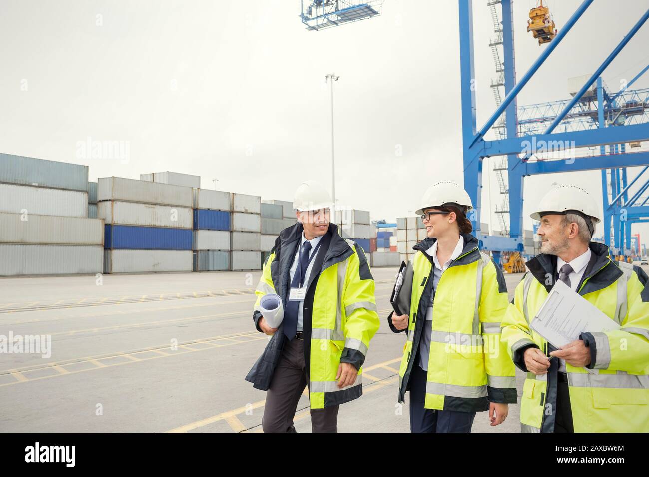 Hafenarbeiter und Manager laufen und reden auf der Werft Stockfoto