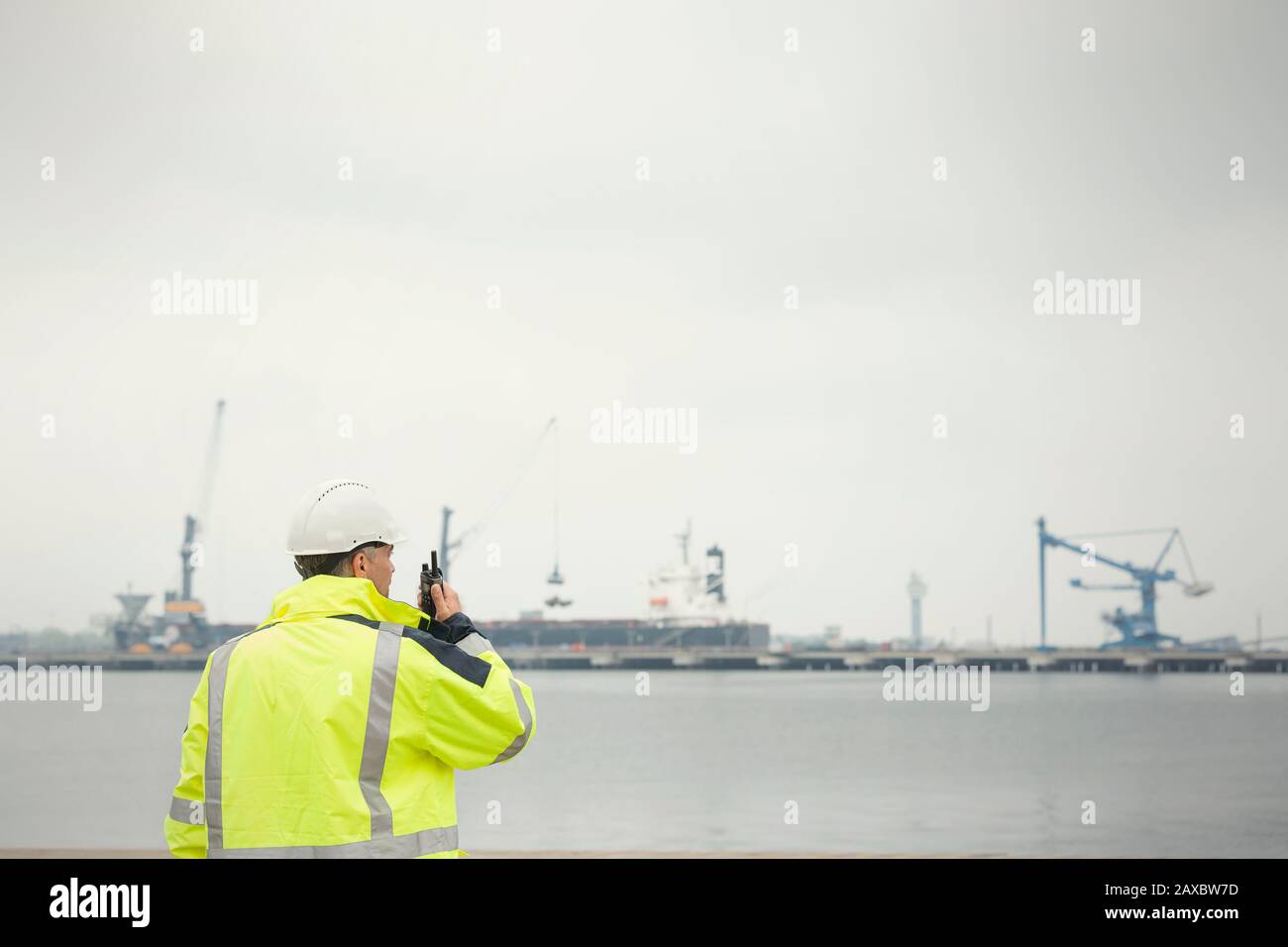 Hafenarbeiter mit Walkie-Talkie am kommerziellen Dock Stockfoto