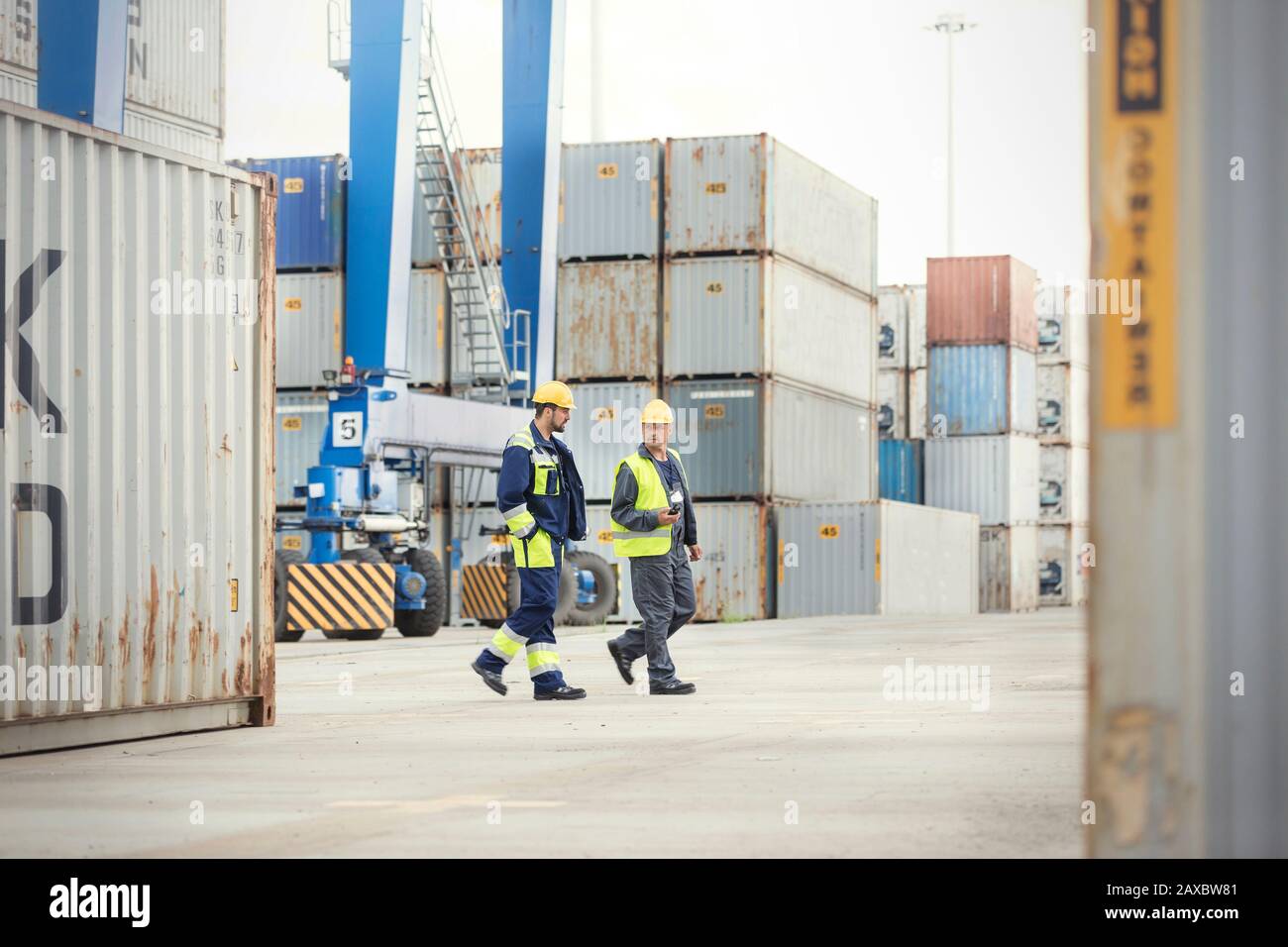 Hafenarbeiter, die auf der Werft spazieren gehen und reden Stockfoto