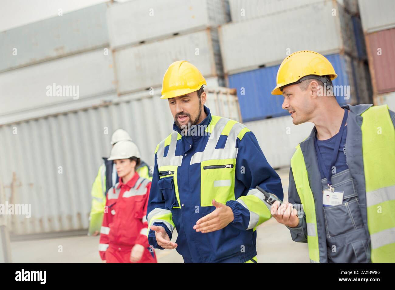 Hafenarbeiter, die auf der Werft spazieren gehen und reden Stockfoto