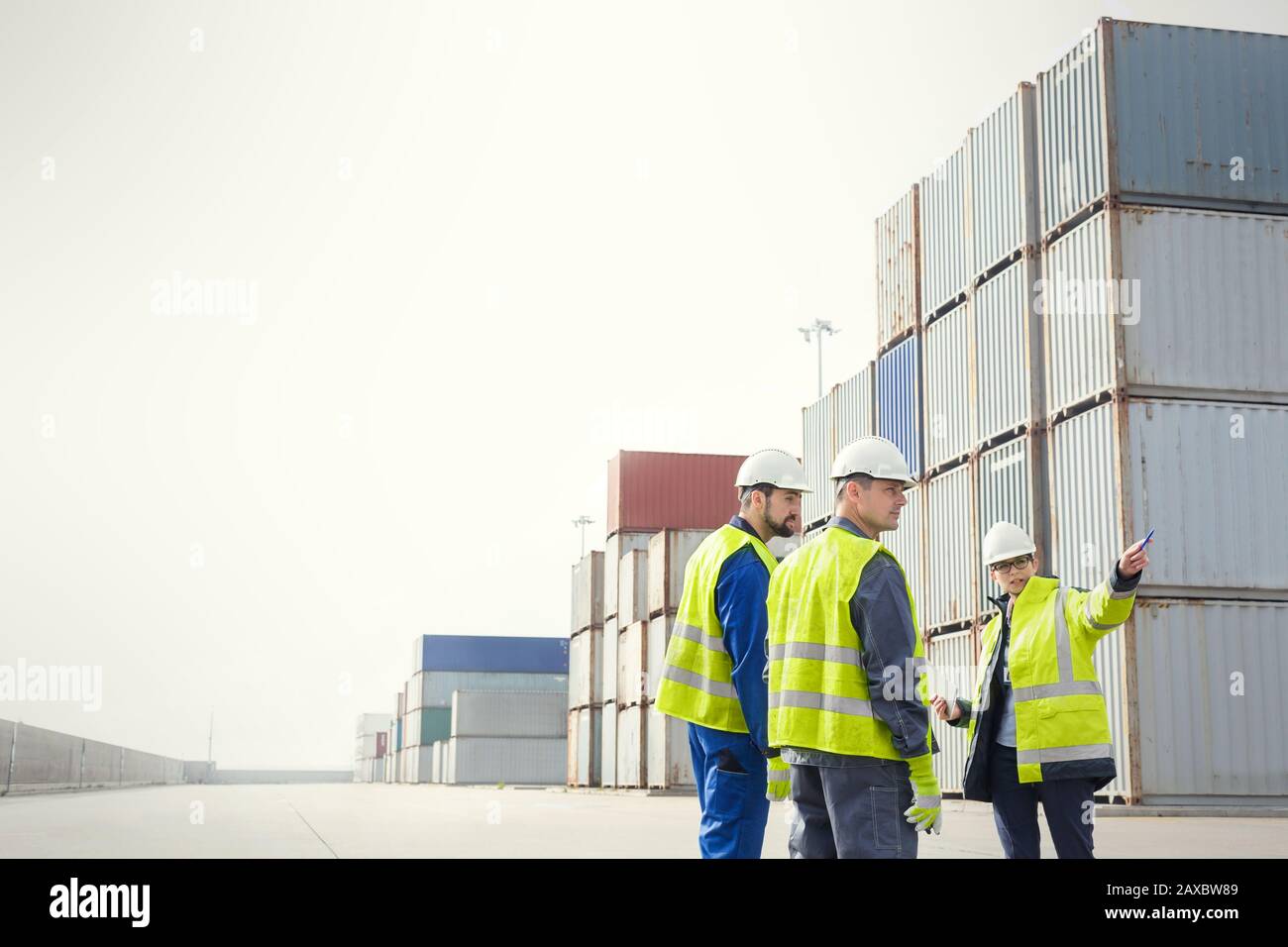 Hafenarbeiter und Manager sprechen in Frachtcontainern auf der Werft Stockfoto