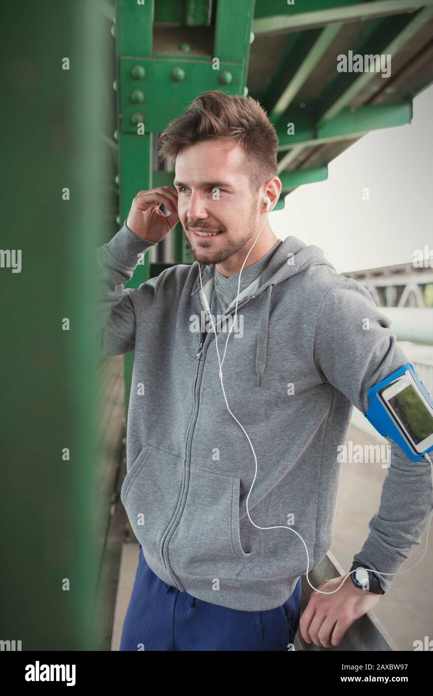 Junger männlicher Läufer mit MP3-Player Armband und Kopfhörer Stockfoto