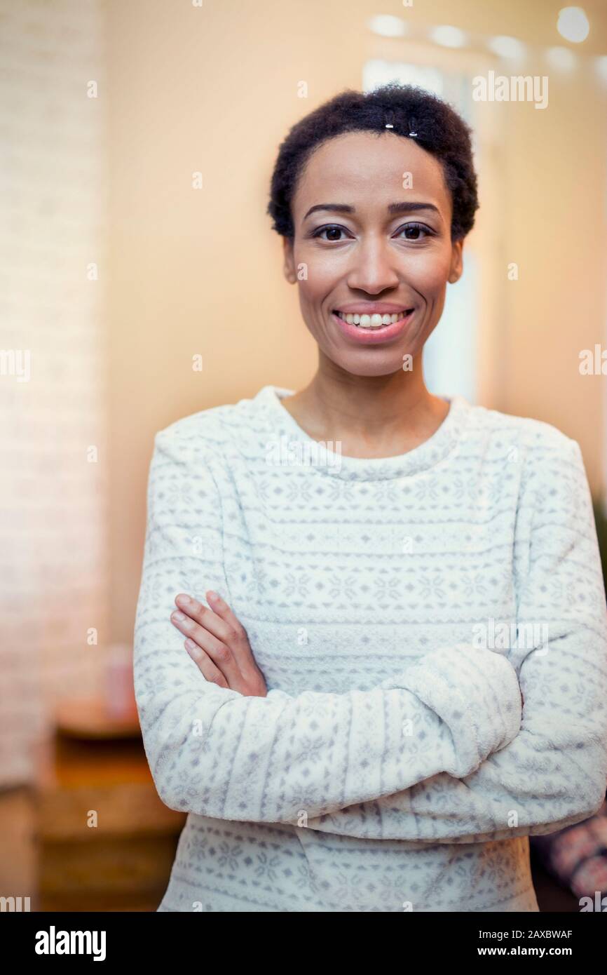Portrait selbstbewusste, lächelnde Frau mit gekreuzten Armen Stockfoto